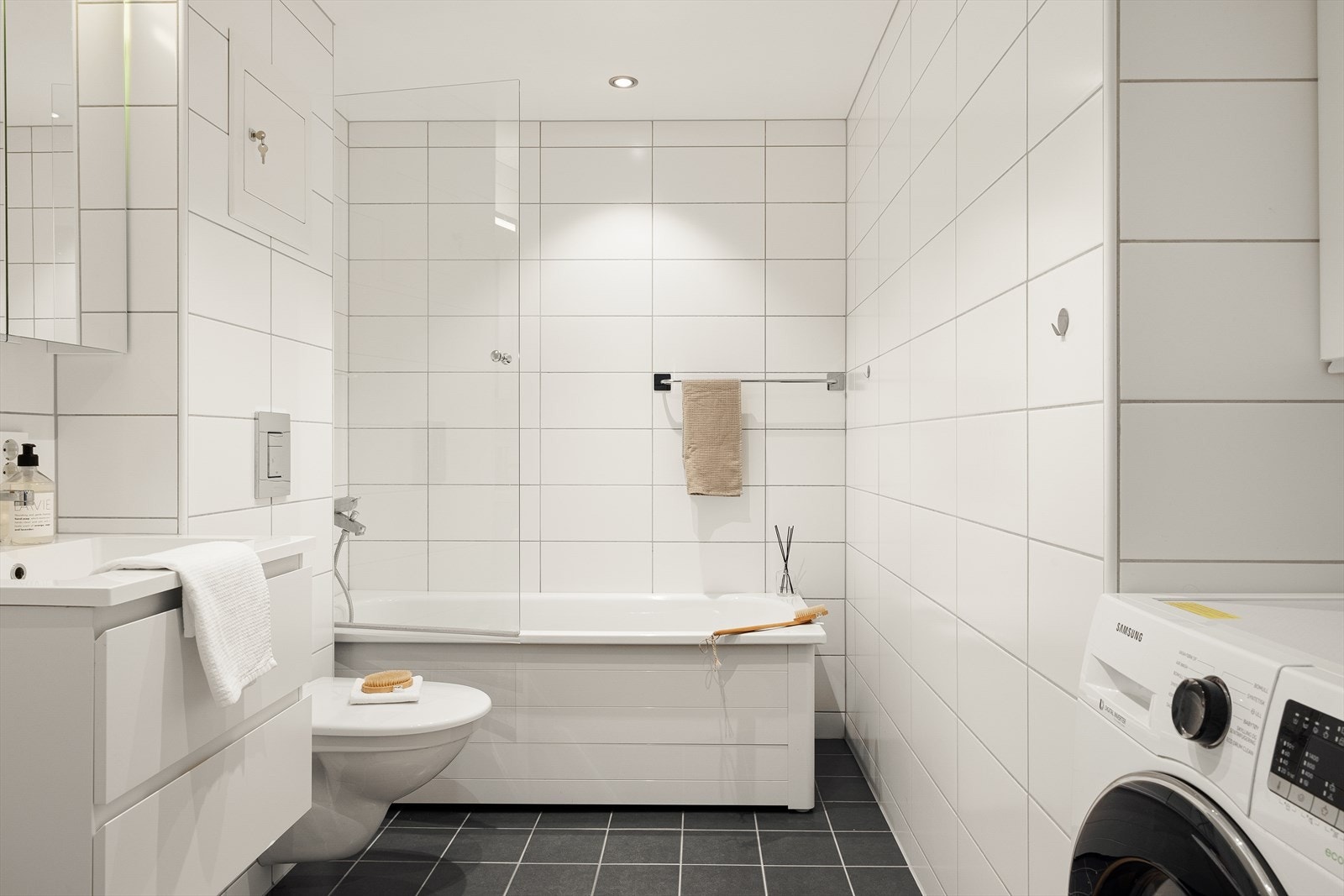 Leiligheten har et flott helfliset bad som ble oppgradert i 2015. Badet inneholder vegghengt toalett, helstøpt servant, skuffer under servant med slette fronter, skap over med speilfront, badekar, opplegg for vaskemaskin og fordelerskap til rørsystemet. Galleribilde