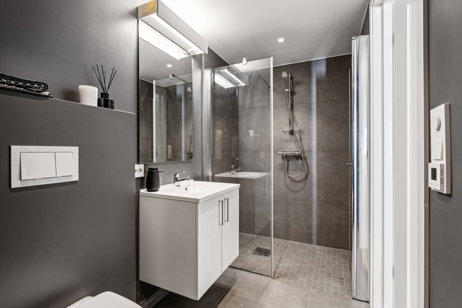 Baderommet har flislagt gulv og dusjsone Galleribilde