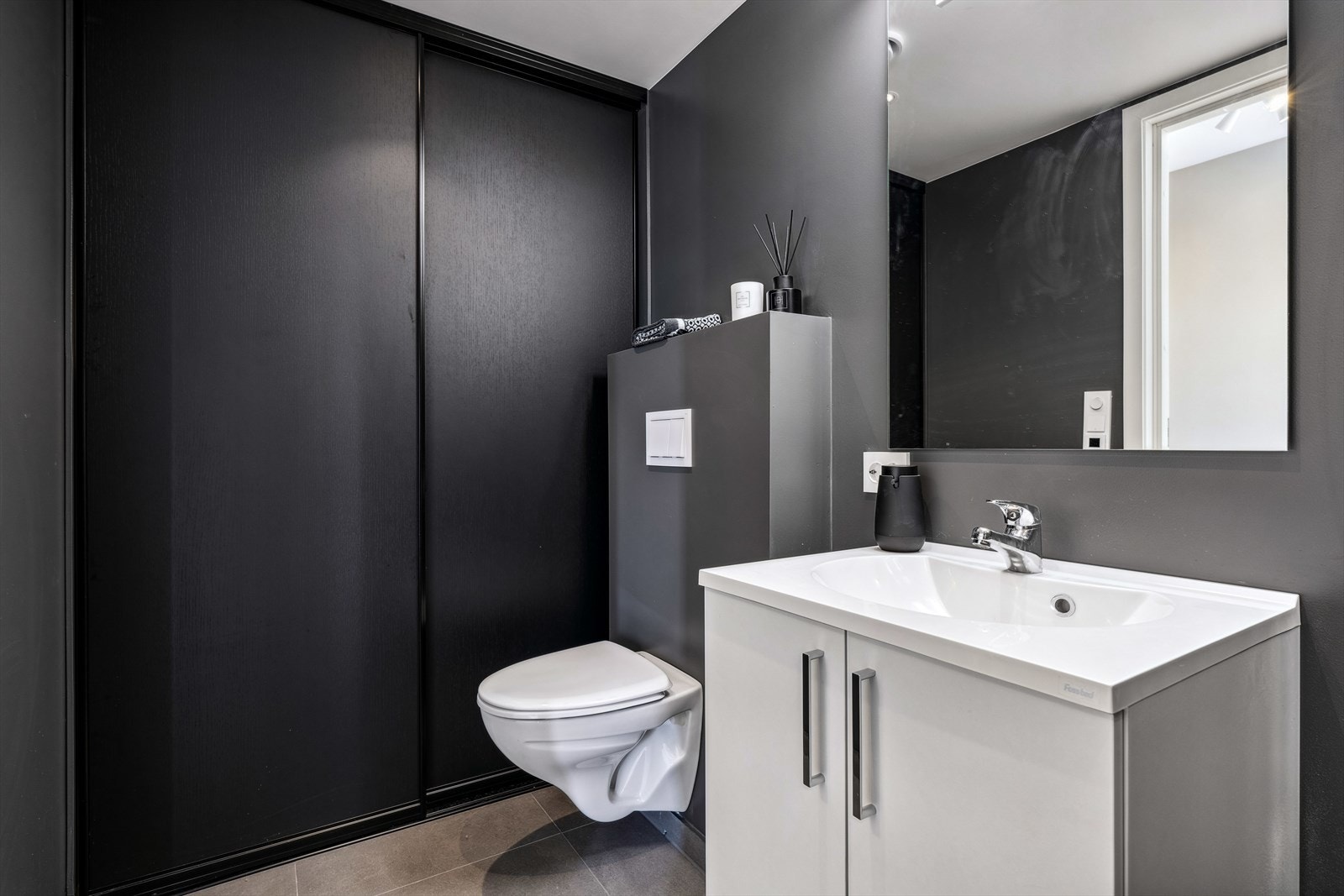 Baderom med opplegg til vaskemaskin og teknisk bag skyvedørsgarderobe Galleribilde