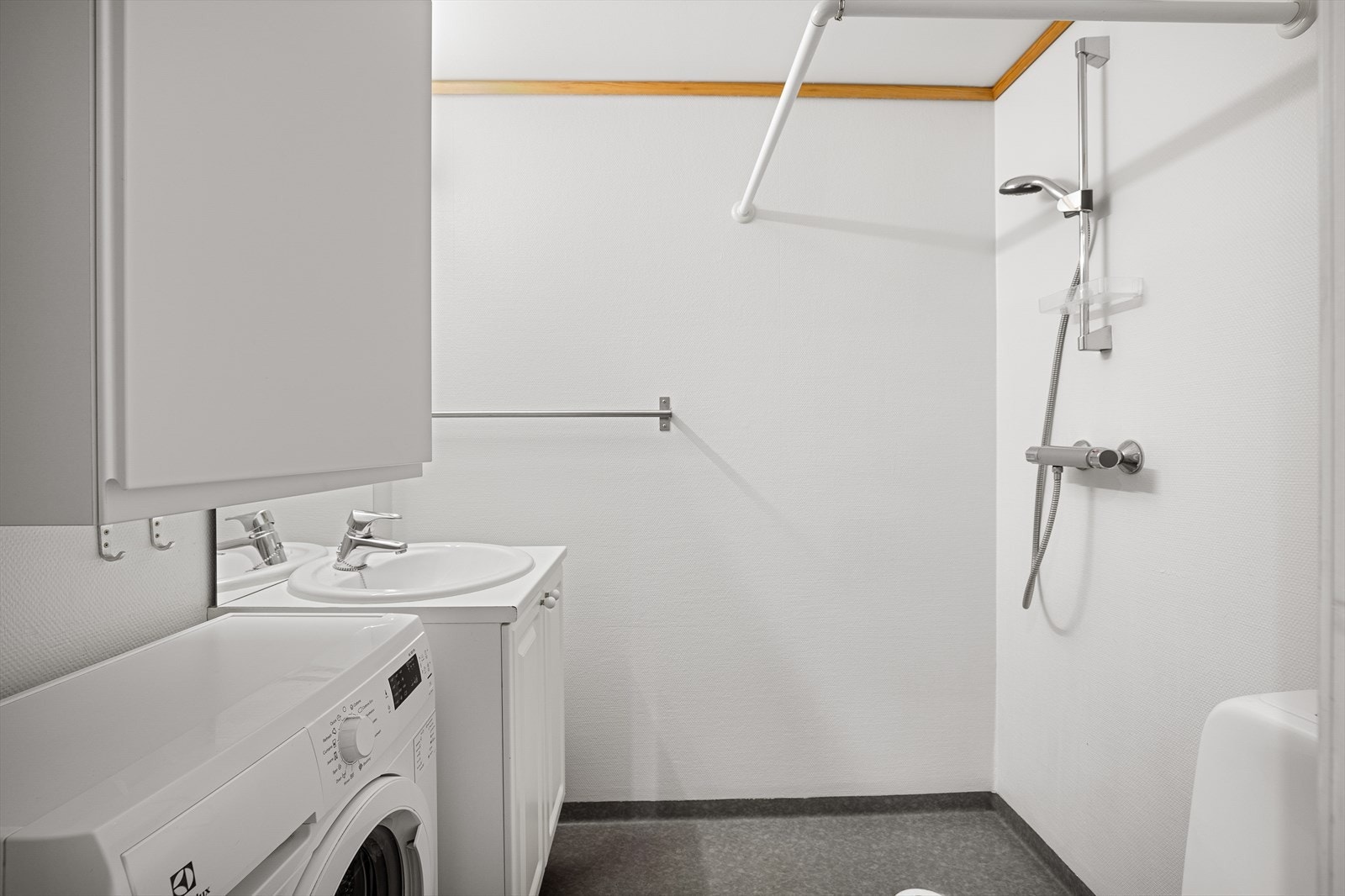 Baderommet er utstyrt med dusjhjørne, mekanisk avtrekk, toalett, servant i skap og hovedstoppeventil i tak. Her er det også behagelig elektrisk varme i gulv. Vaskemaskin vil medfølge handelen. Galleribilde