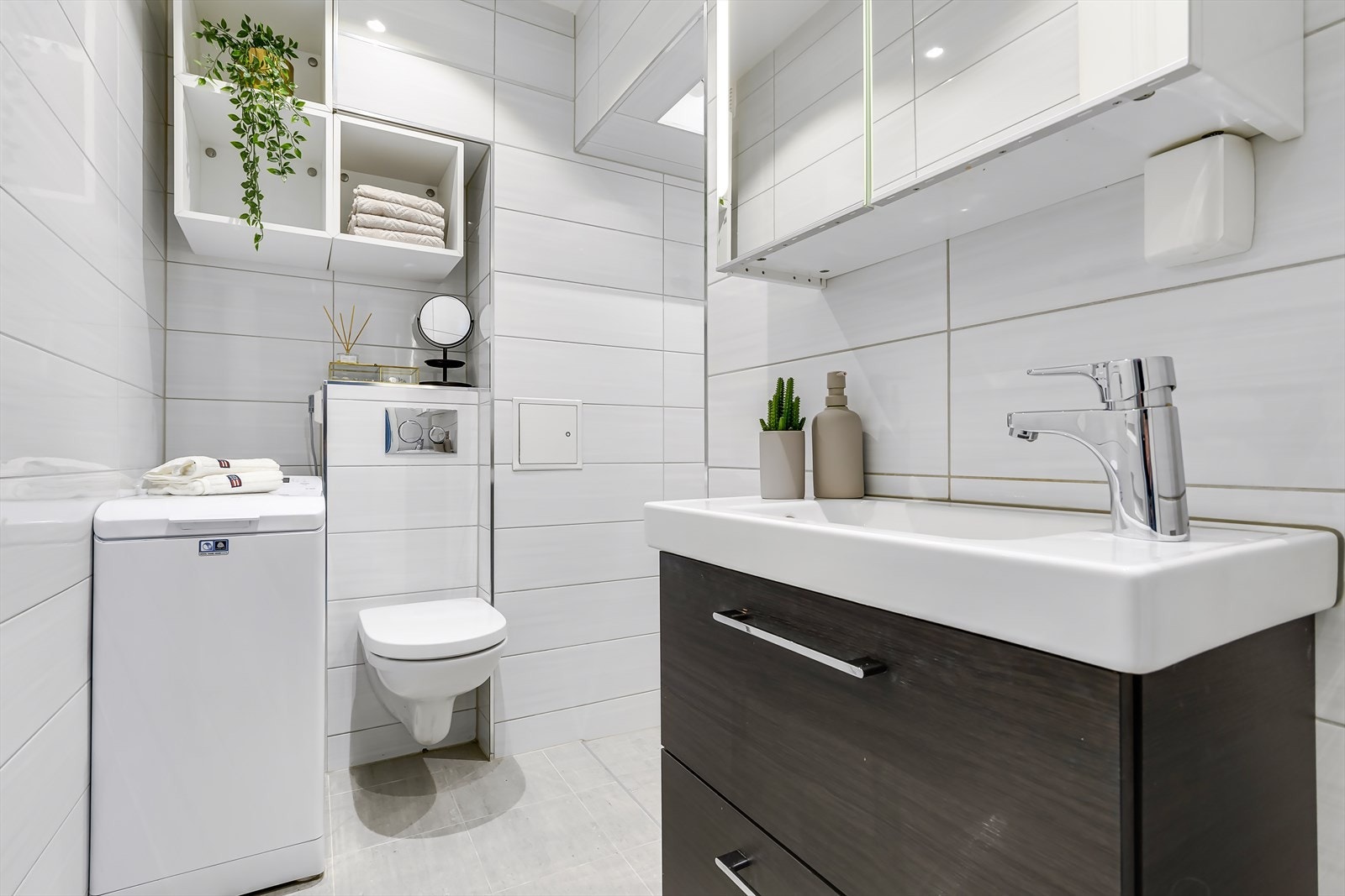 Lekkert og klassisk flislagt bad fra 2017 med gulvvarme, downlights i taket og opplegg for vaskemaskin. Galleribilde