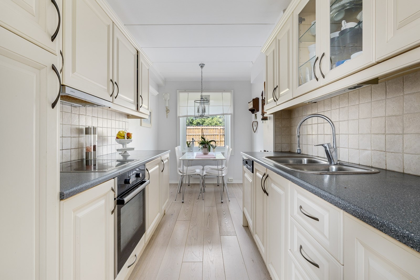 Kjøkkenet har innredning med profilerte fronter. Benkeplaten er av laminat med fliser på vegg over benker. Det er integrerte hvitevarer som kjøleskap, oppvaskmaskin, induksjonstopp og stekeovn. Galleribilde