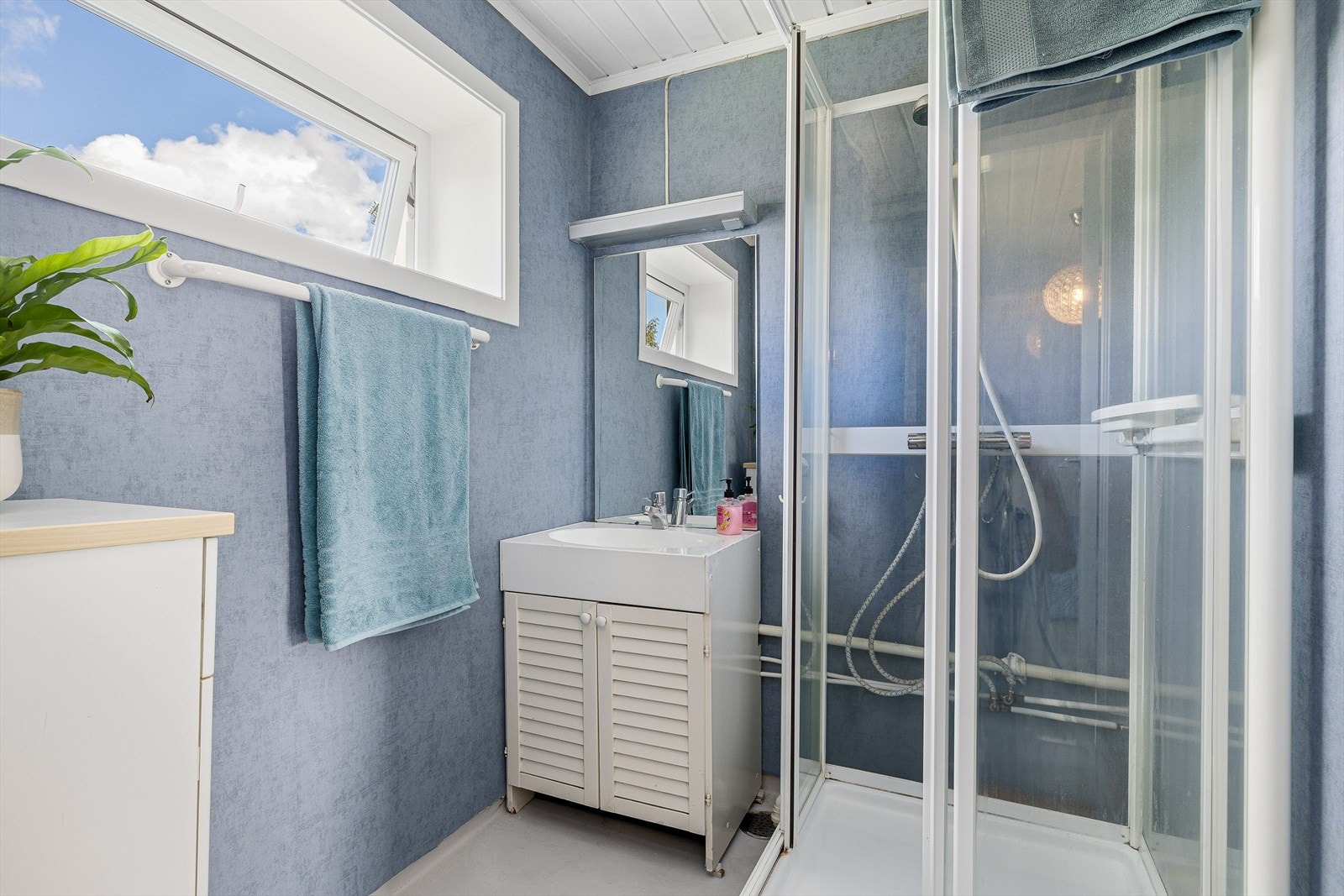 Baderom med malt gulvbelegg i hulkil og våtromstapet på vegger. Malt panel i himling. Innredet med servantskap og dusjkabinett. Galleribilde