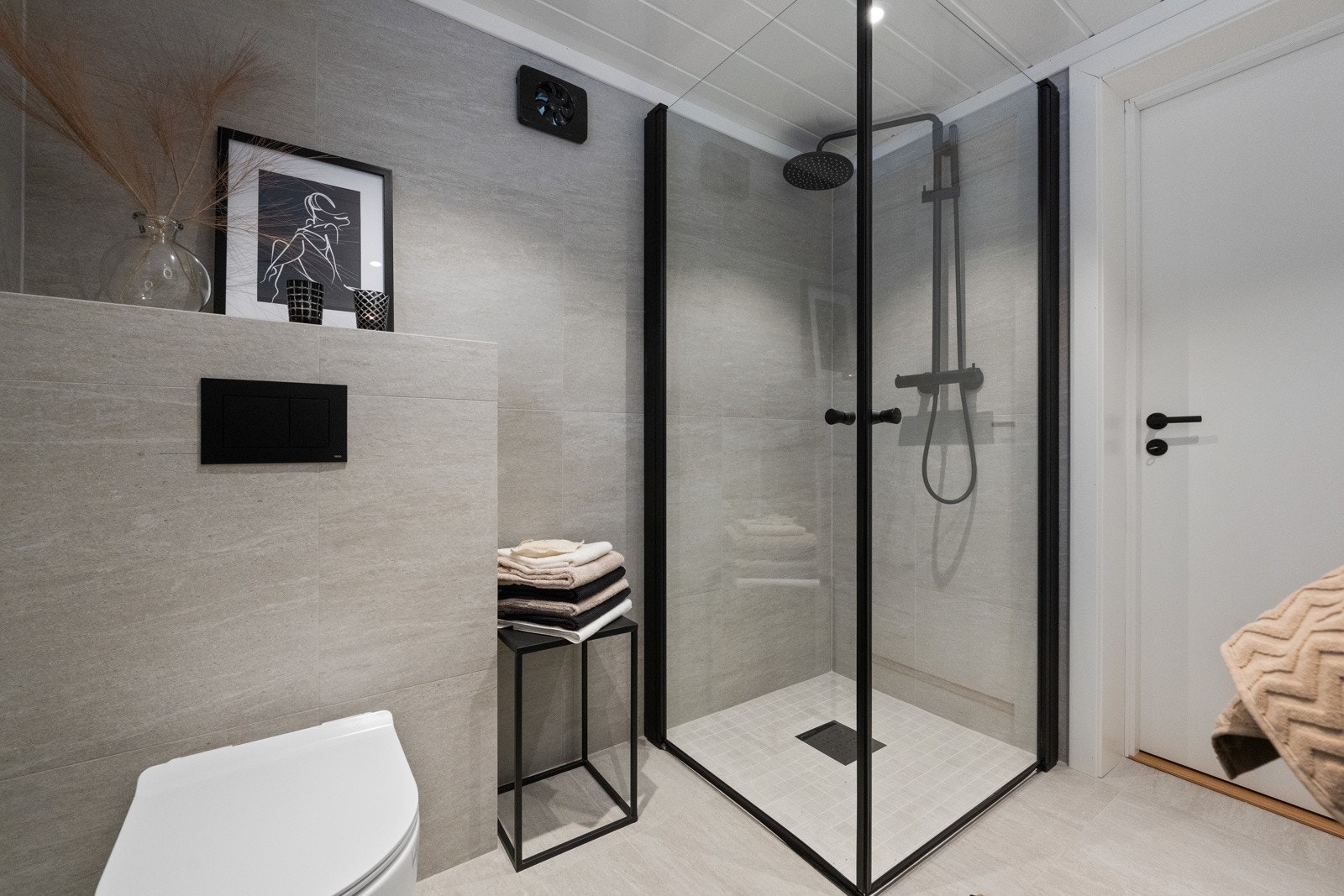 Badet er utstyrt med servant med underskap, speil med tilhørende belysning, dusjvegger og vegghengt wc. Det er opplegg for vaskemaskin. Galleribilde
