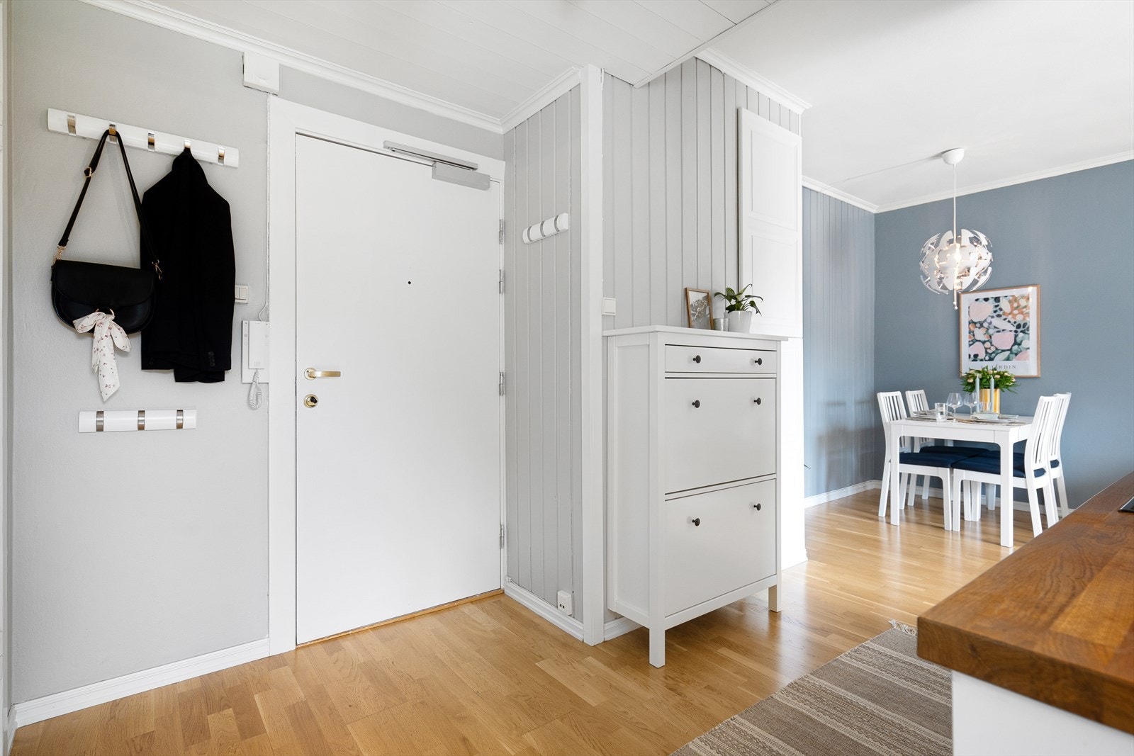 Leiligheten har en innbydende entré som skaper et umiddelbart godt førsteinntrykk. Her kan du enkelt henge i fra deg yttertøy på knaggrekke. Galleribilde