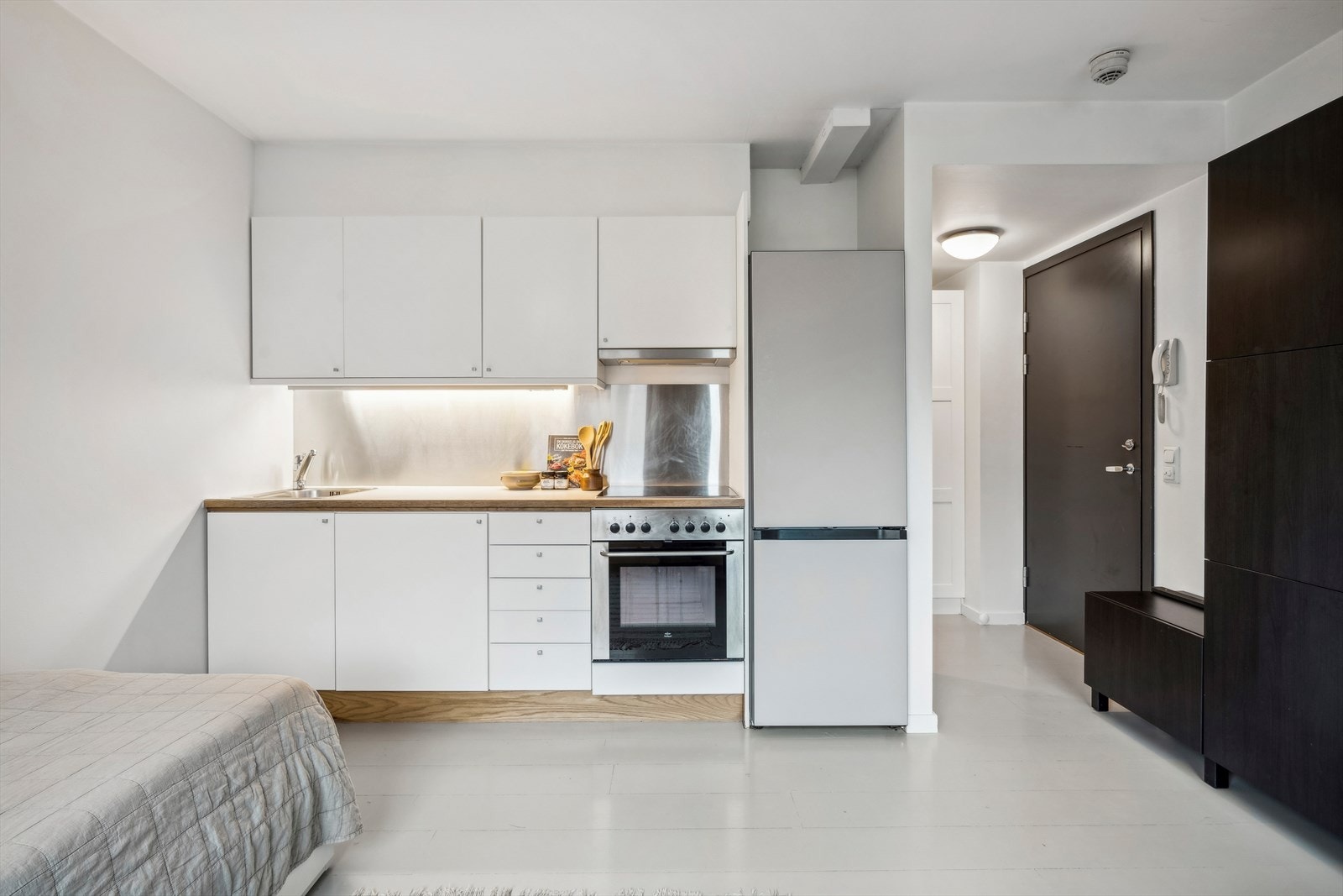 Lys kjøkkeninnredning med glatte skapfronter og laminert benkeplate. Galleribilde