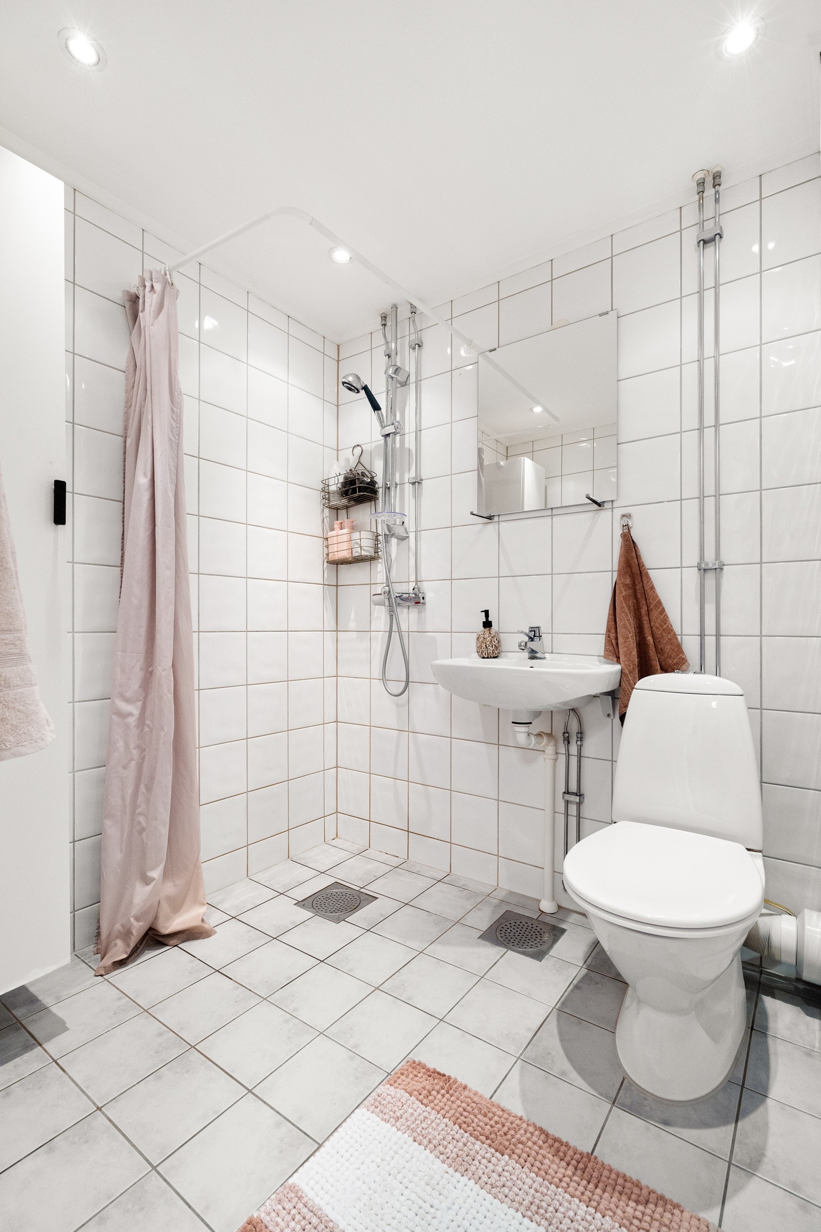 Pent bad/wc, flislagt i tidløs stil med downlights og varmekabler i gulvet. Galleribilde