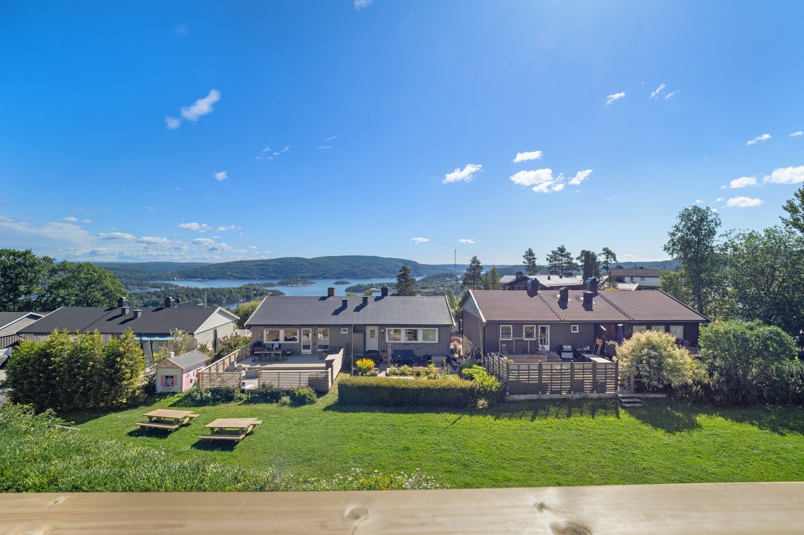 Utsikt fra balkongen til fellesarealer på nedsiden og ned mot fjorden Galleribilde