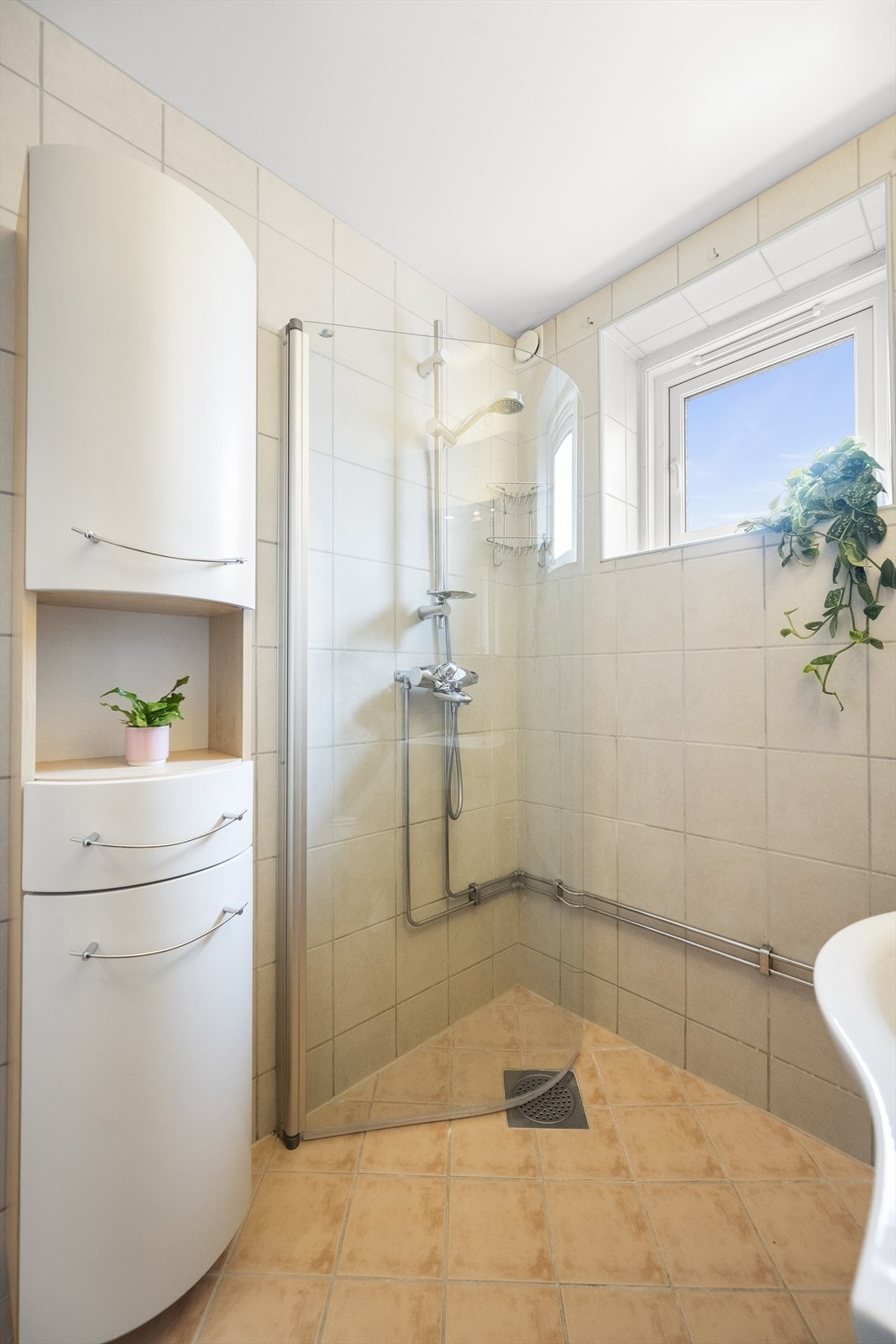 Badet har varmekabler i gulv, innfellbare dusjdører, servant med oppbevaring og vegghengt toalett Galleribilde