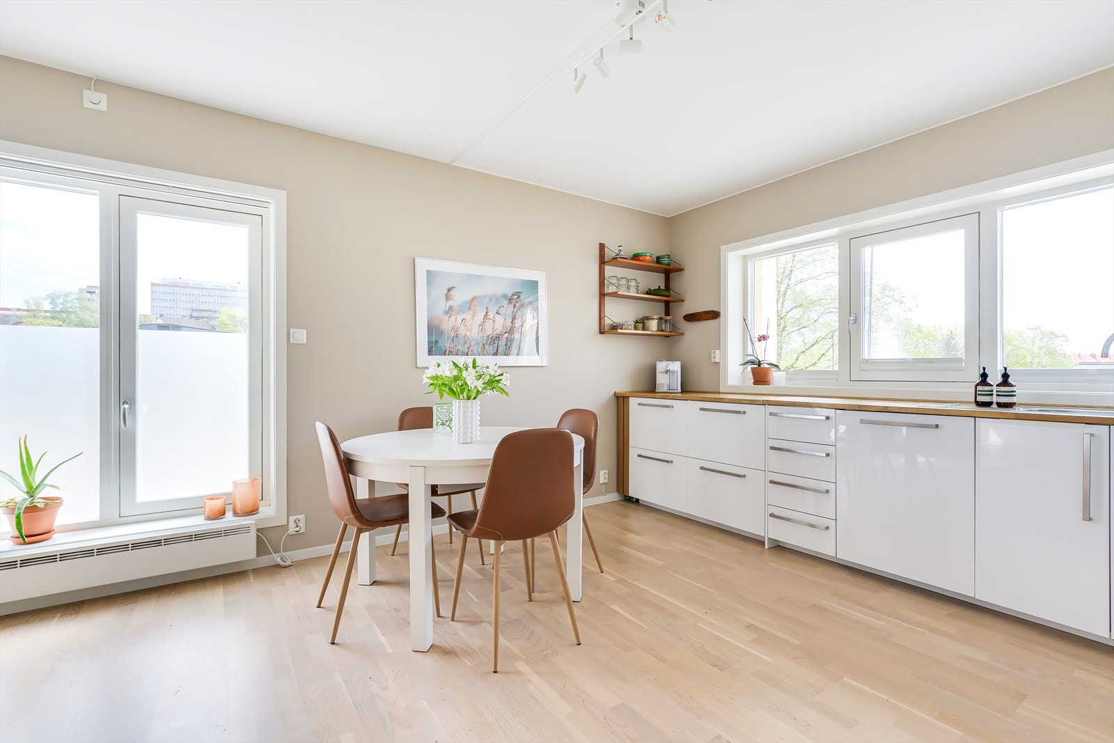 Stilrent kjøkken fra 2015 med hvite fronter, fliser på bakvegg og x- benkeplate. Galleribilde