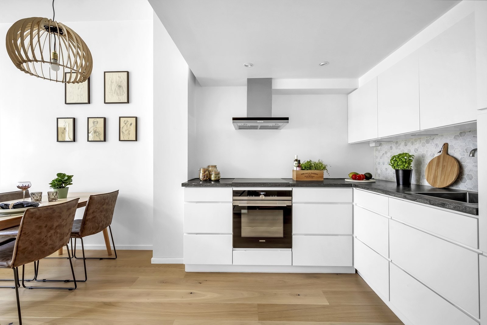 Det er fliser og belysning over deler av benkeplaten. Videre er det integrert koketopp med avtrekk over kokeplassen, stekeovn, oppvaskmaskin og kjøl-/fryseskap. Galleribilde