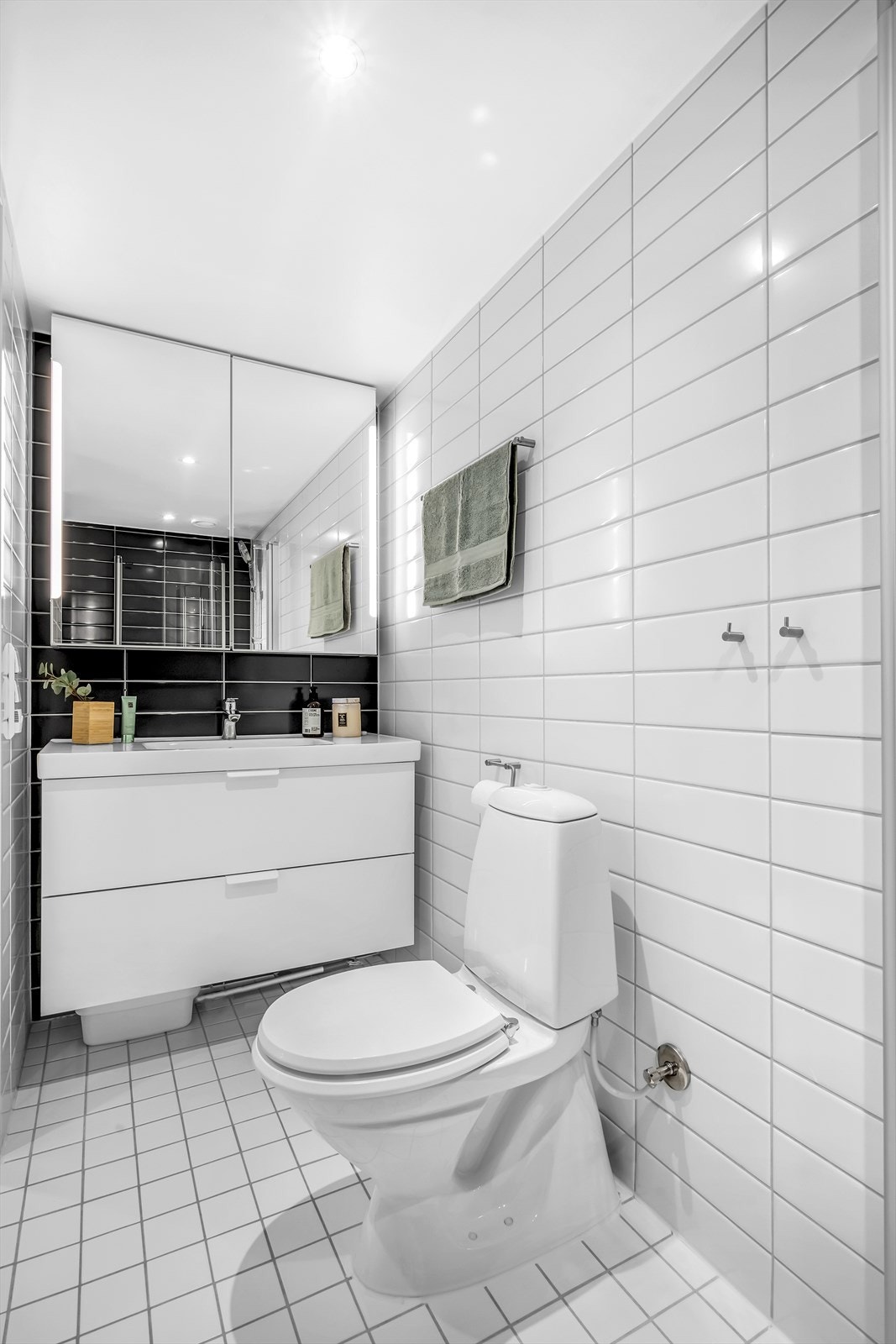 Pent flislagt baderom med gulvvarme og downlights. Baderommet er innredet med klosett, servant med innredning, speilskap med lys og har dusjhjørne med svingbare glassdører. Galleribilde