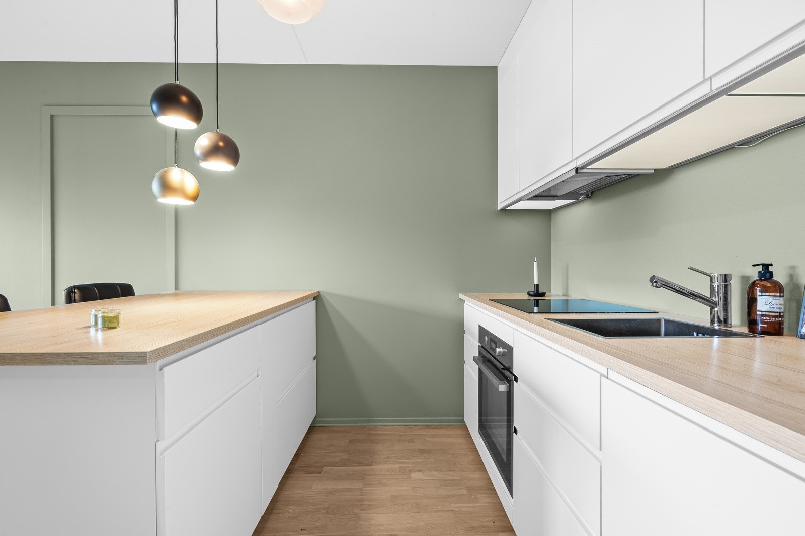 Innredningen har slette fronter i hvit utførelse og benkeplate av laminat med nedsenket oppvaskkum og ett-greps armatur. Galleribilde