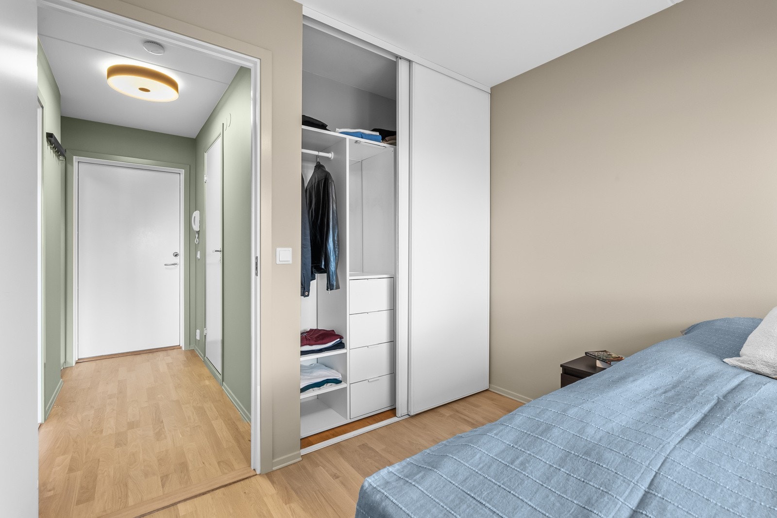 Rikelig oppbevaringsplass i skyvedørsgarderobe med skuffer, hyller og kleshengerstativ i innredningen. Galleribilde