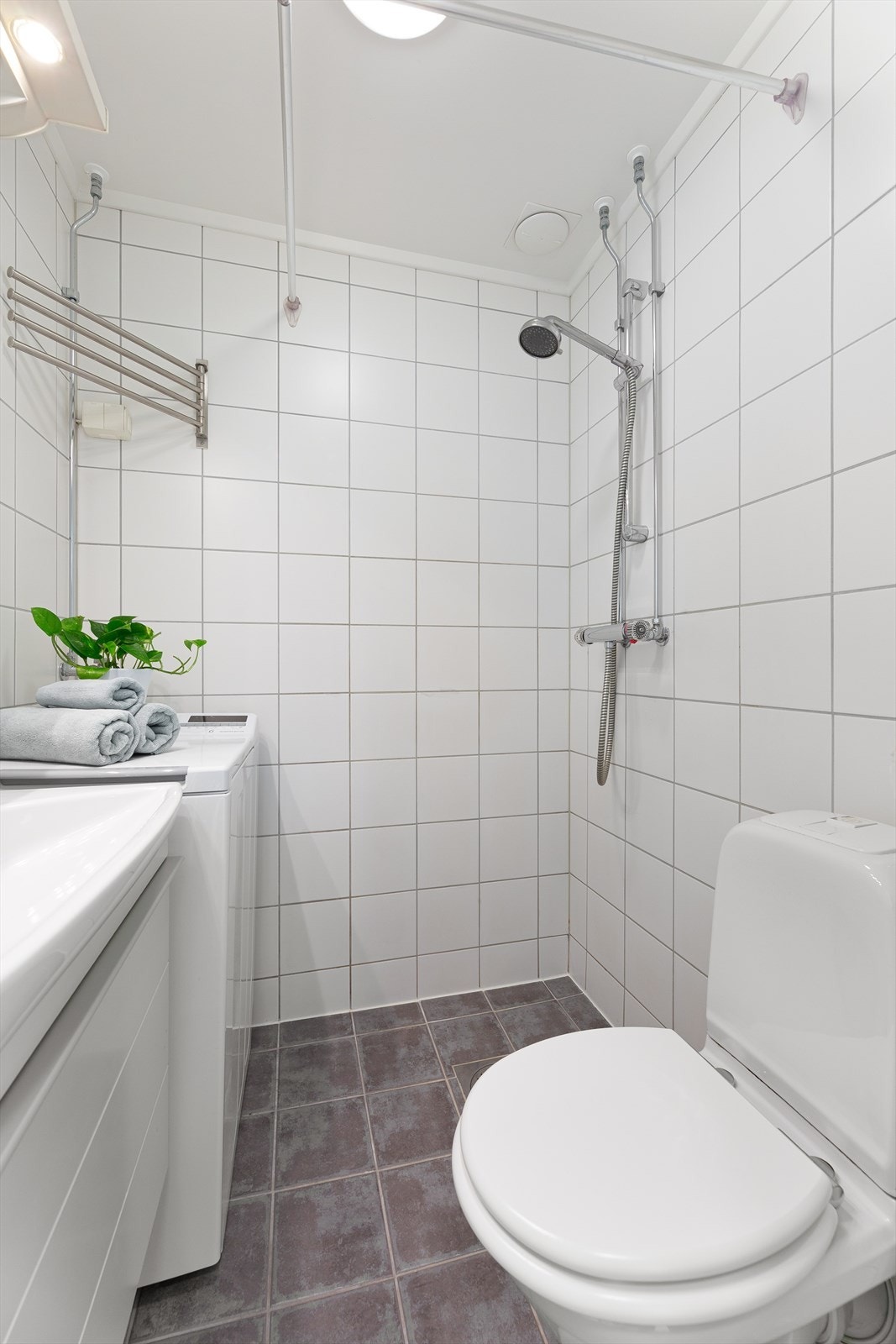 Baderom med dusj, servant med skuffer og toalett. Galleribilde