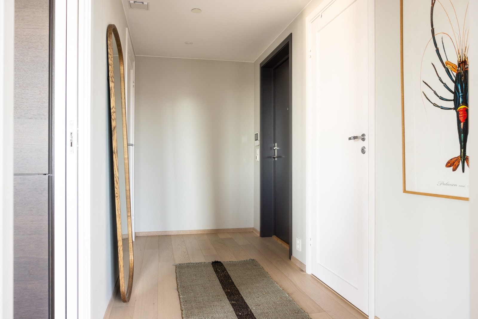 Man ankommer leiligheten i en innbydende entré med downlights i himling, parkett på gulv og en behagelige vannbåren gulvvarme. Galleribilde