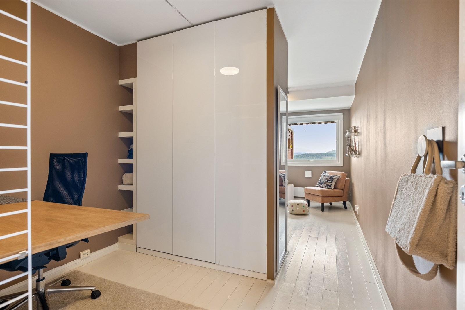 Soverommet er delt med garderobeskap og innebygd hylle, som gir en praktisk sone til f.eks. skrivebord. Galleribilde