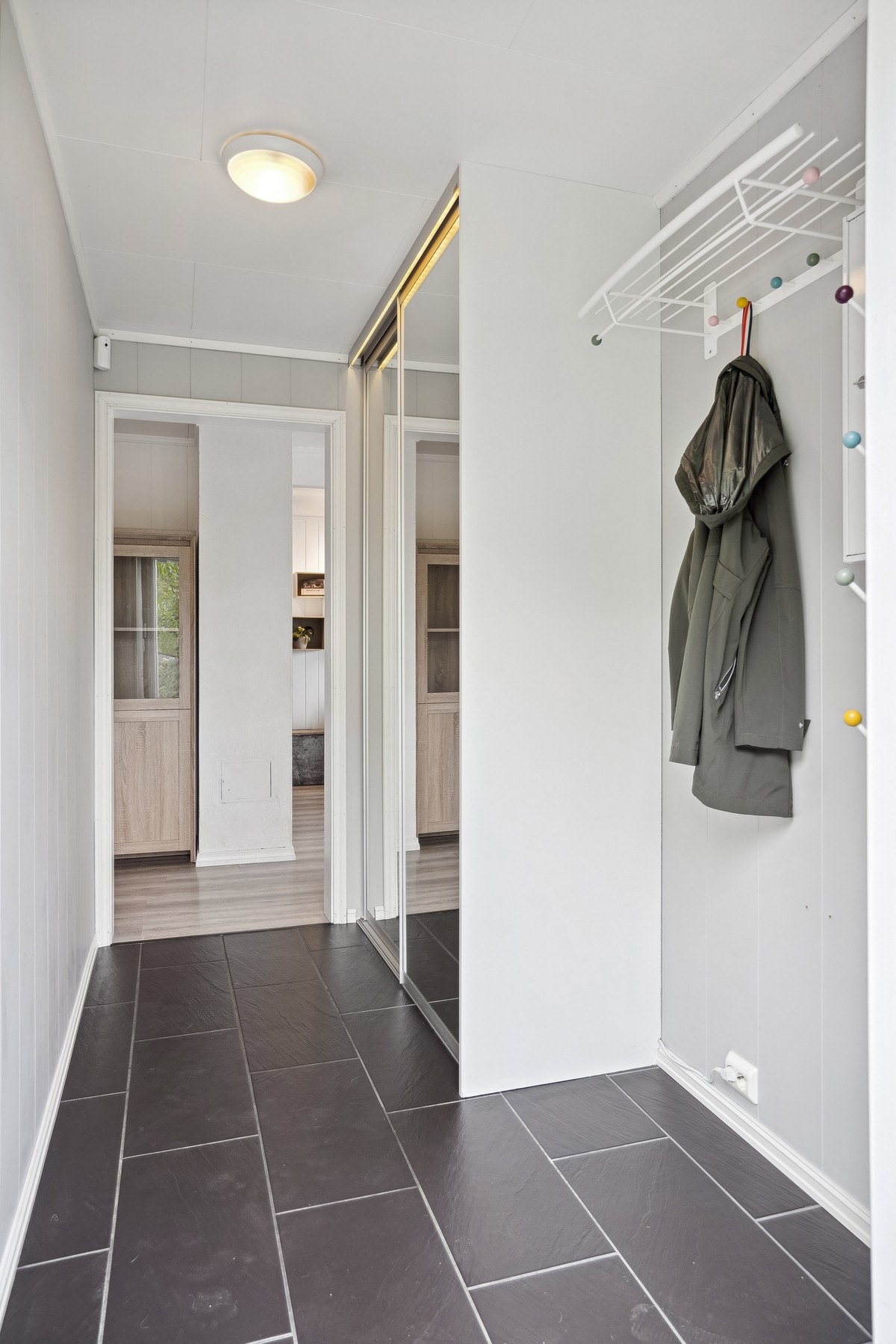 Flislagt entre med skyvedørdsgarderobe. Galleribilde