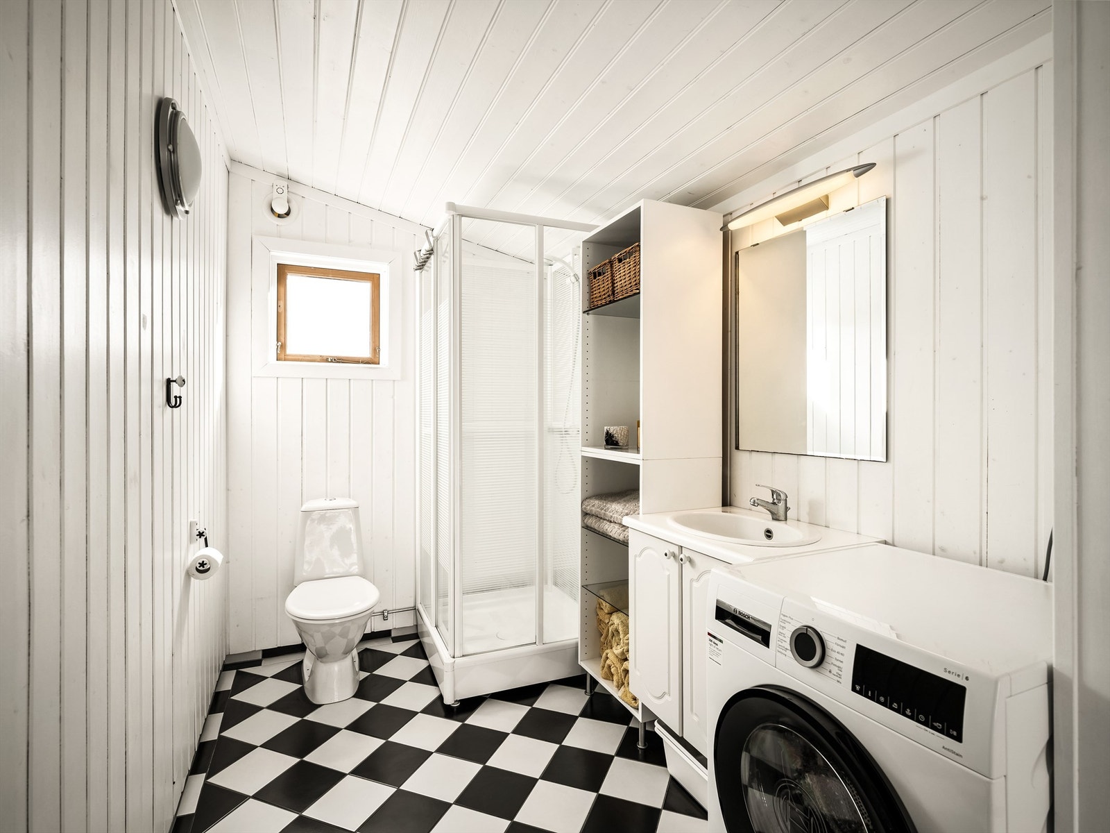 Dusjkabinett begrenser vannpåkjenning på overflatene. Veggene er av malt trepanel, gulvet er utført med fliser og varme. Galleribilde