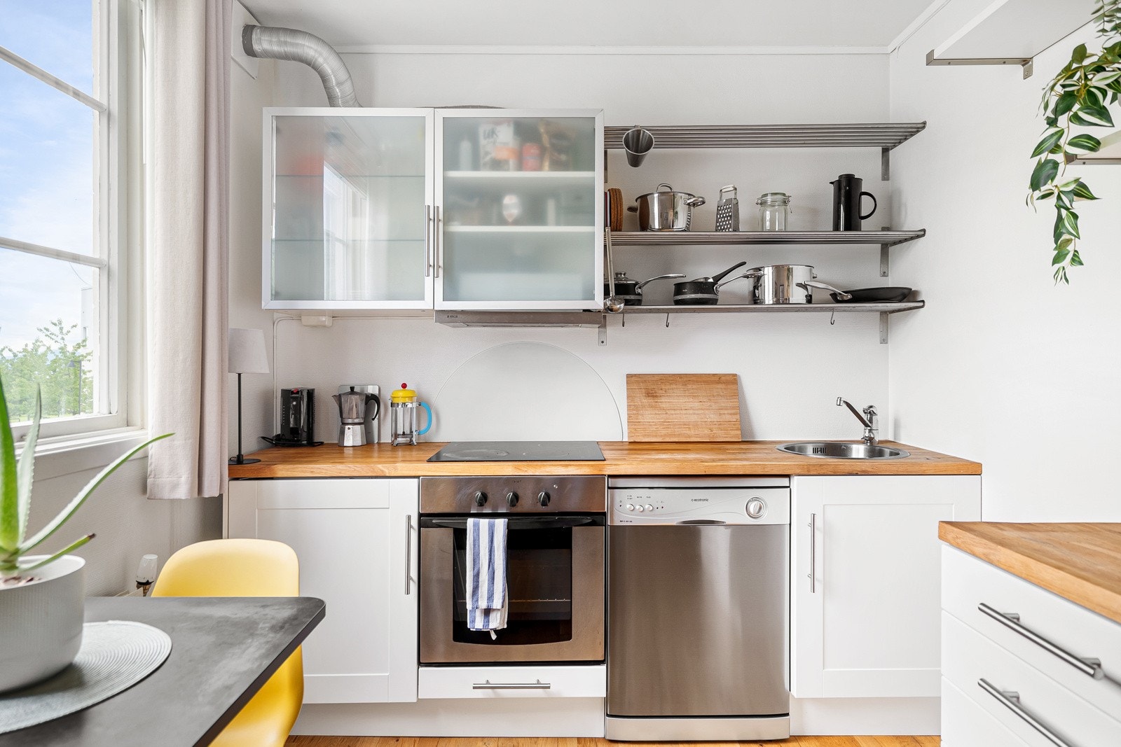 Kjøkkenet er fra IKEA og har en lekker benkeplate av tre. Til tross for en mindre leilighet, er dette tilnærmet et full-size kjøkken med vaskemaskin, induksjonstopp og stekeovn. Galleribilde