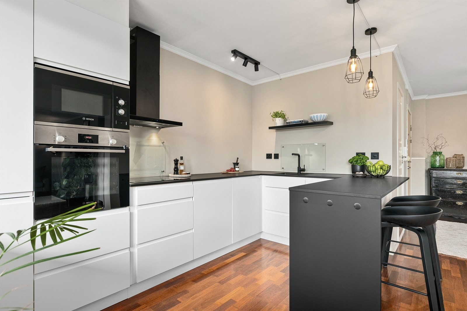 God benkeplass og glassplater på vegg over induksjonstopp og oppvaskkum. Galleribilde