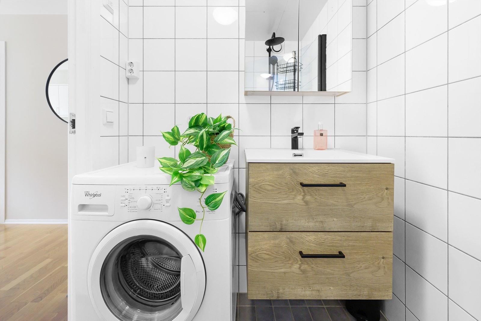 Badet er innredet med dusjhjørne, vegghengt wc, servant med underskap, speil med skap samt opplegg for vaskemaskin. På badet er det også varmekabler i gulvet. Galleribilde