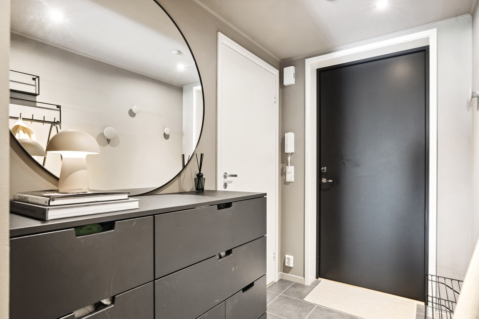 Leiligheten har en innbydende entré med mørke fliser på gulvet og pent malte vegger. Galleribilde