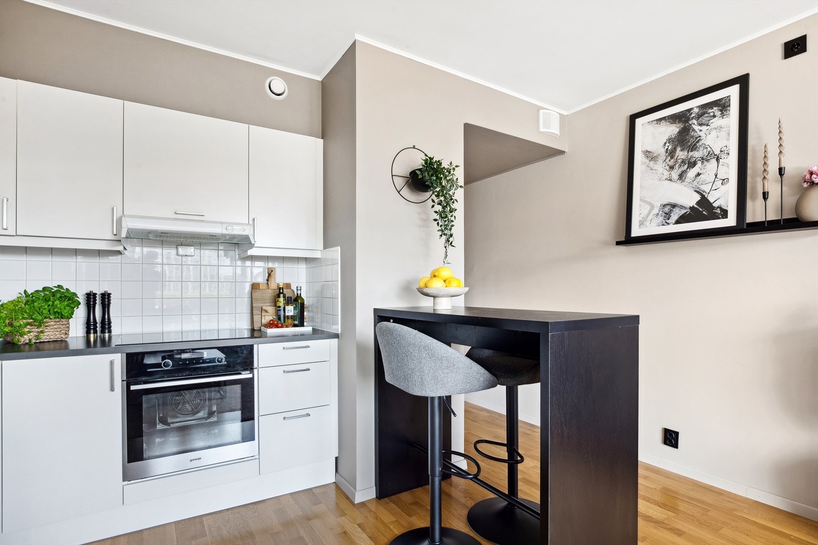 Fliser på veggen mellom benk og skap gjør det enkelt å holde kjøkkenet rent, samtidig som det gir et stilrent uttrykk. Galleribilde