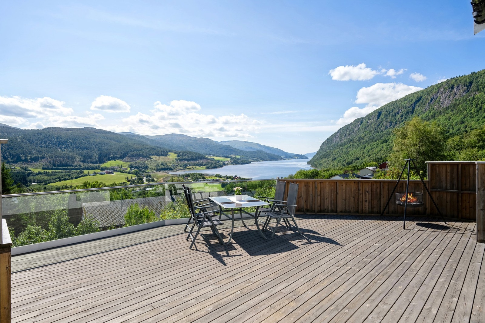 Kombinasjonen av glassrekkverk og tett trerekkverk gir en lun og samtidig luftig uteplass. Galleribilde