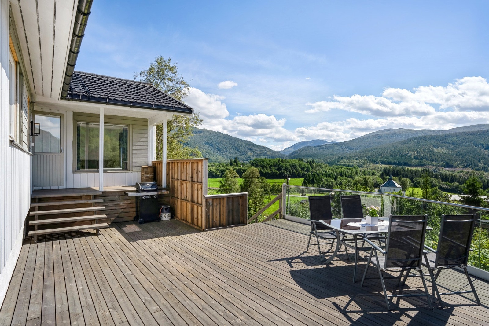 Det er utgang fra stuen i første etasje til en overbygd veranda og en stor, flott terrasse. Galleribilde
