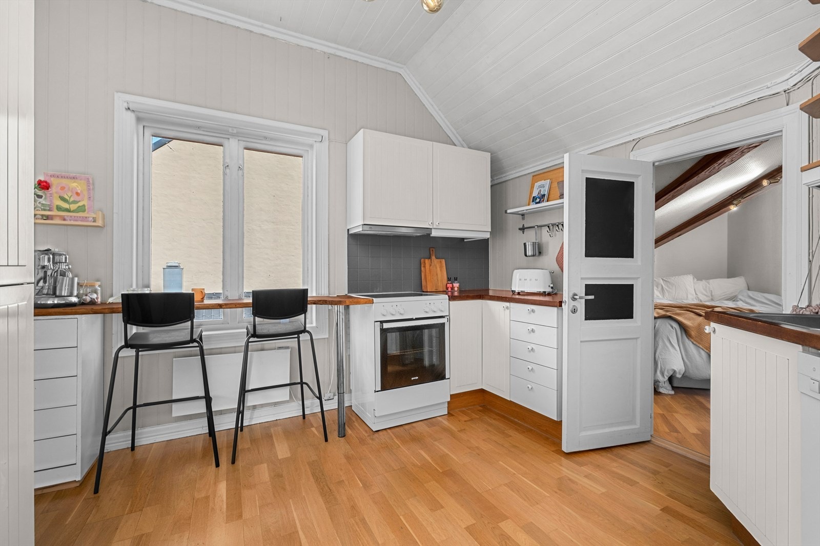 Her får du en gjennomtenkt kjøkkenløsning som sørger for romslig med "arbeidsplass", med både stor benkeplass og egen frokost-sittegruppe. Galleribilde