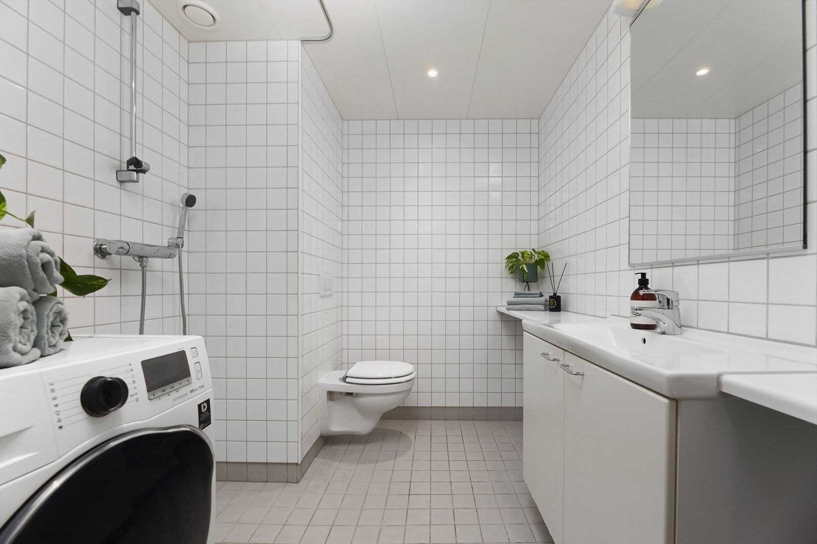 Flislagt baderom med varmekabler i gulvene og downlights i himlingen. Galleribilde