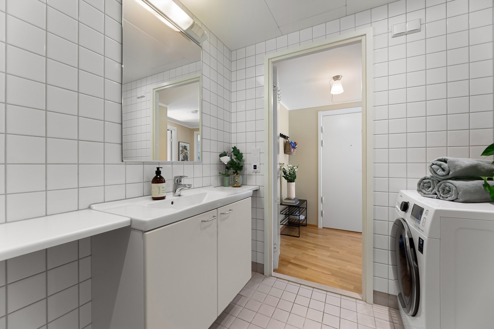 Badet har vegghengt servant med skap og opplegg for vaskemaskin. Galleribilde