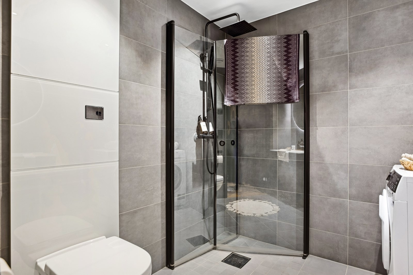 Dusjhjørnet har regnfallsdusj og innfellbare glassdører Galleribilde