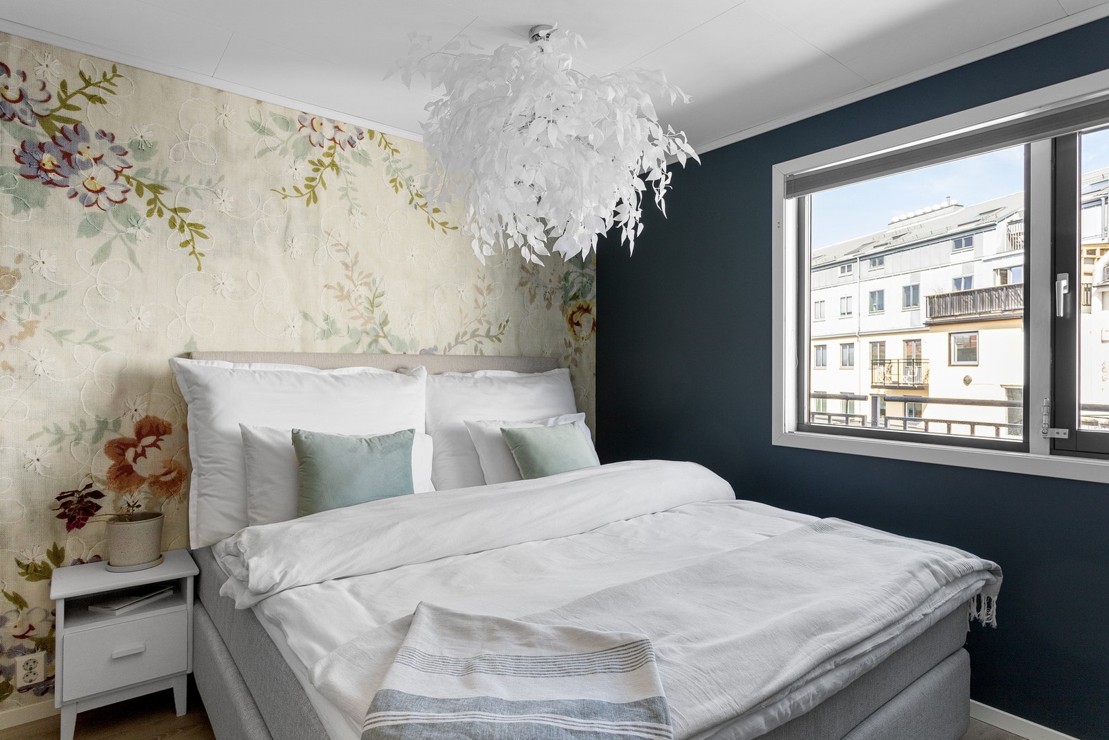 Soverommet gir et elegant uttrykk kombinert med en stilren tapet, samt en lun blåfarge på vegg. Galleribilde