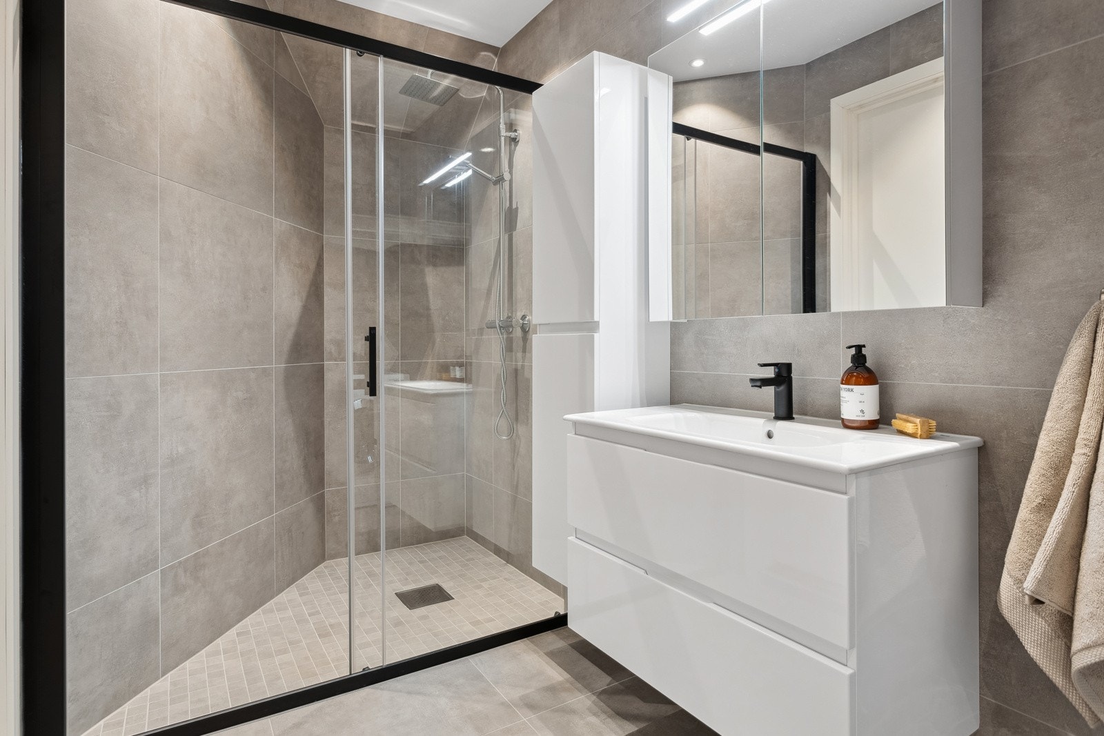 Tilbake i entrèen er det tilkomst til det første av to bad | Helfliset baderom med varmekabler i gulv Galleribilde