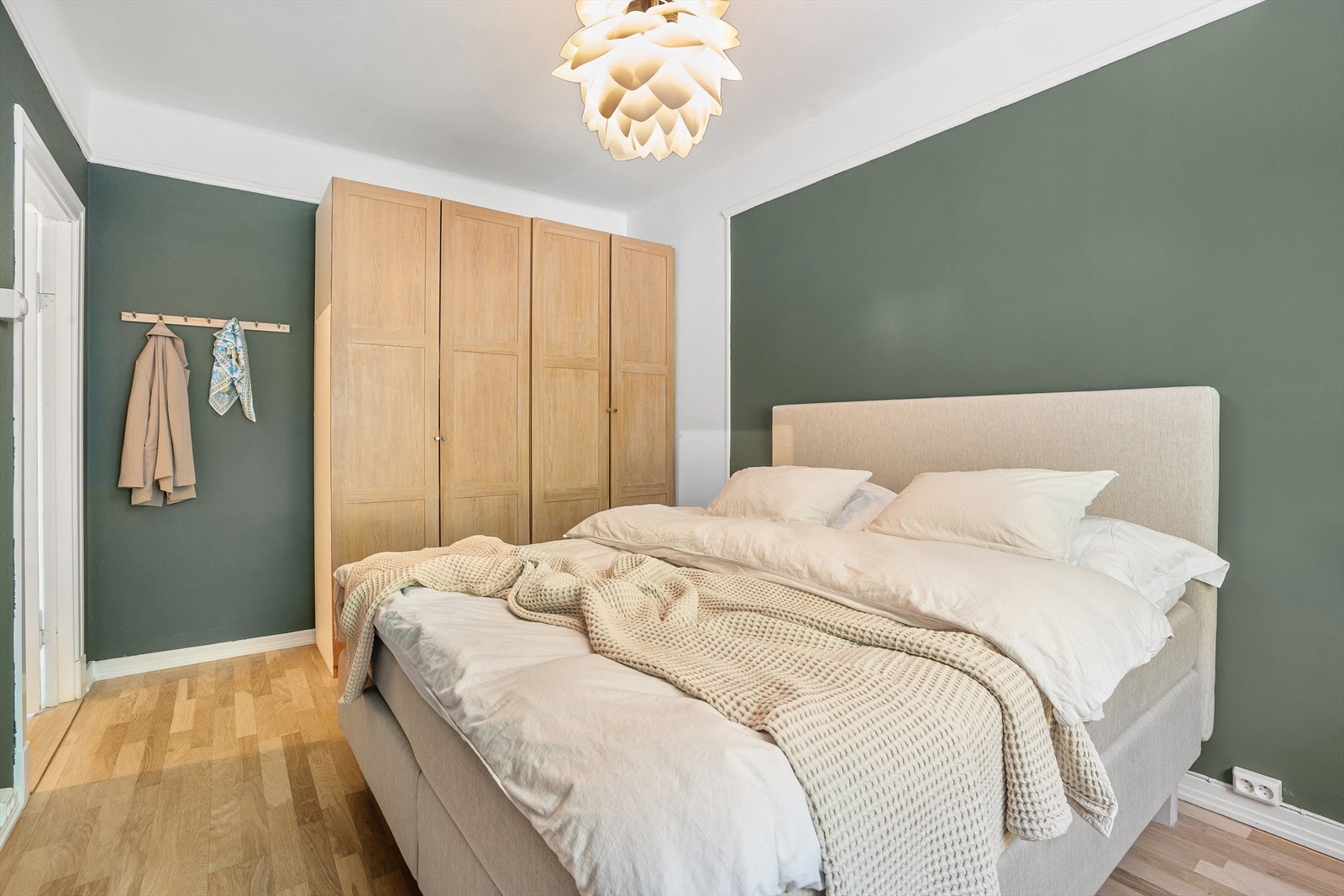 Soverommet har en en lun grønn-tone Galleribilde