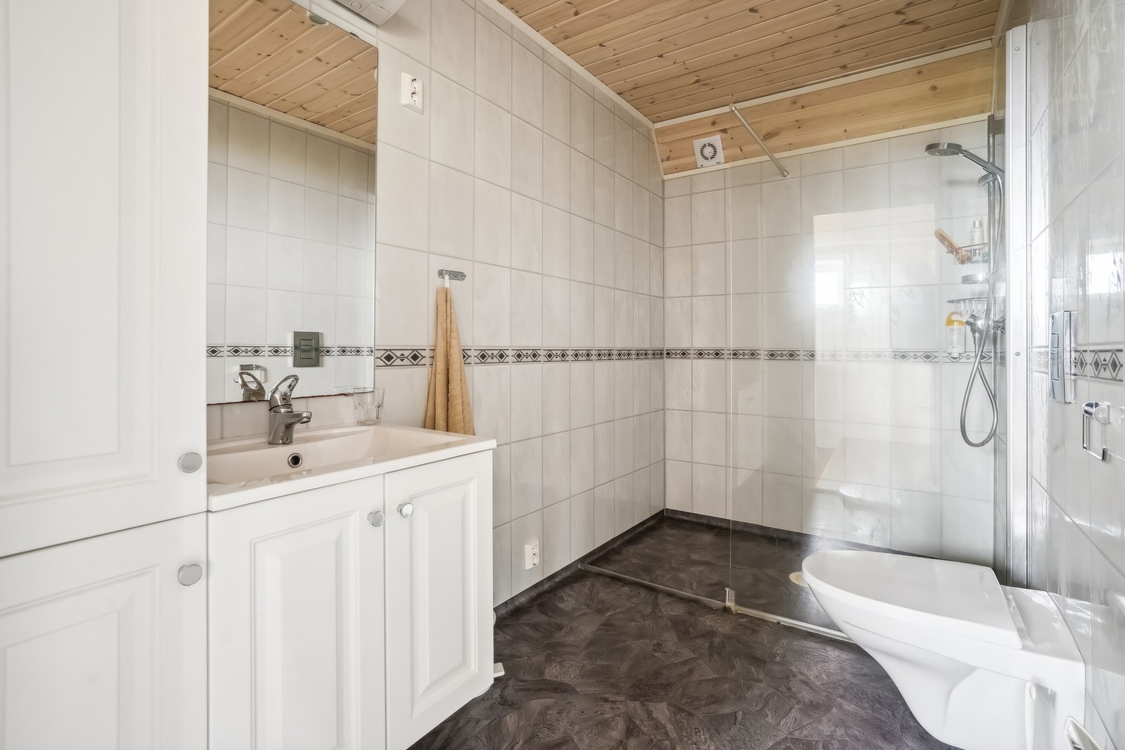 Rommet har innredning med nedfelt servant, toalett, dusjvegger/hjørne og opplegg for vaskemaskin. Galleribilde