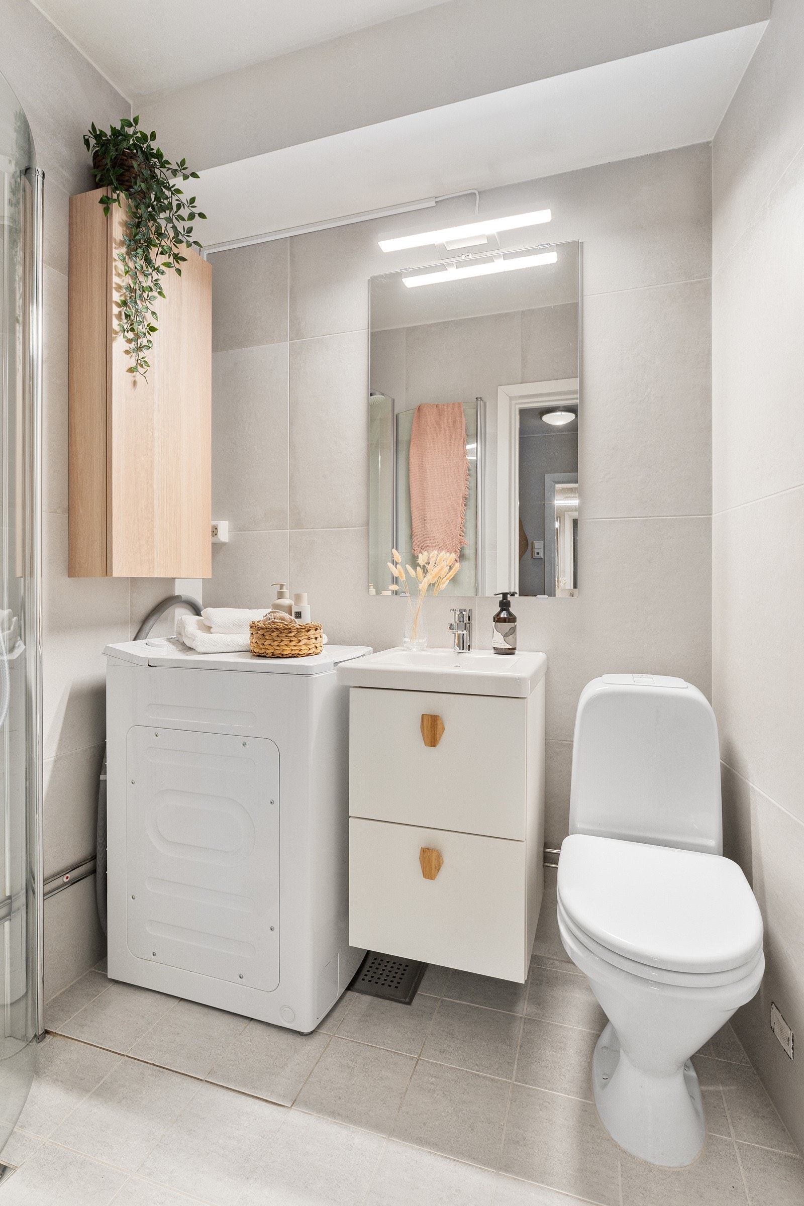 Servant med skap, speil med lys og veggskap. Glassdører til dusj, varmekabler og opplegg til vaskemaskin. Galleribilde