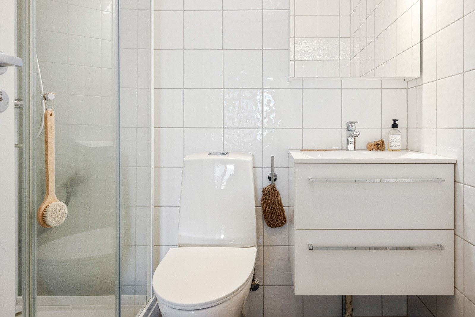 Helfliset bad med varmekabler i gulv. Badet inneholder dusjkabinett, toalett, opplegg for vaskemaskin og baderomsinnredning. Galleribilde