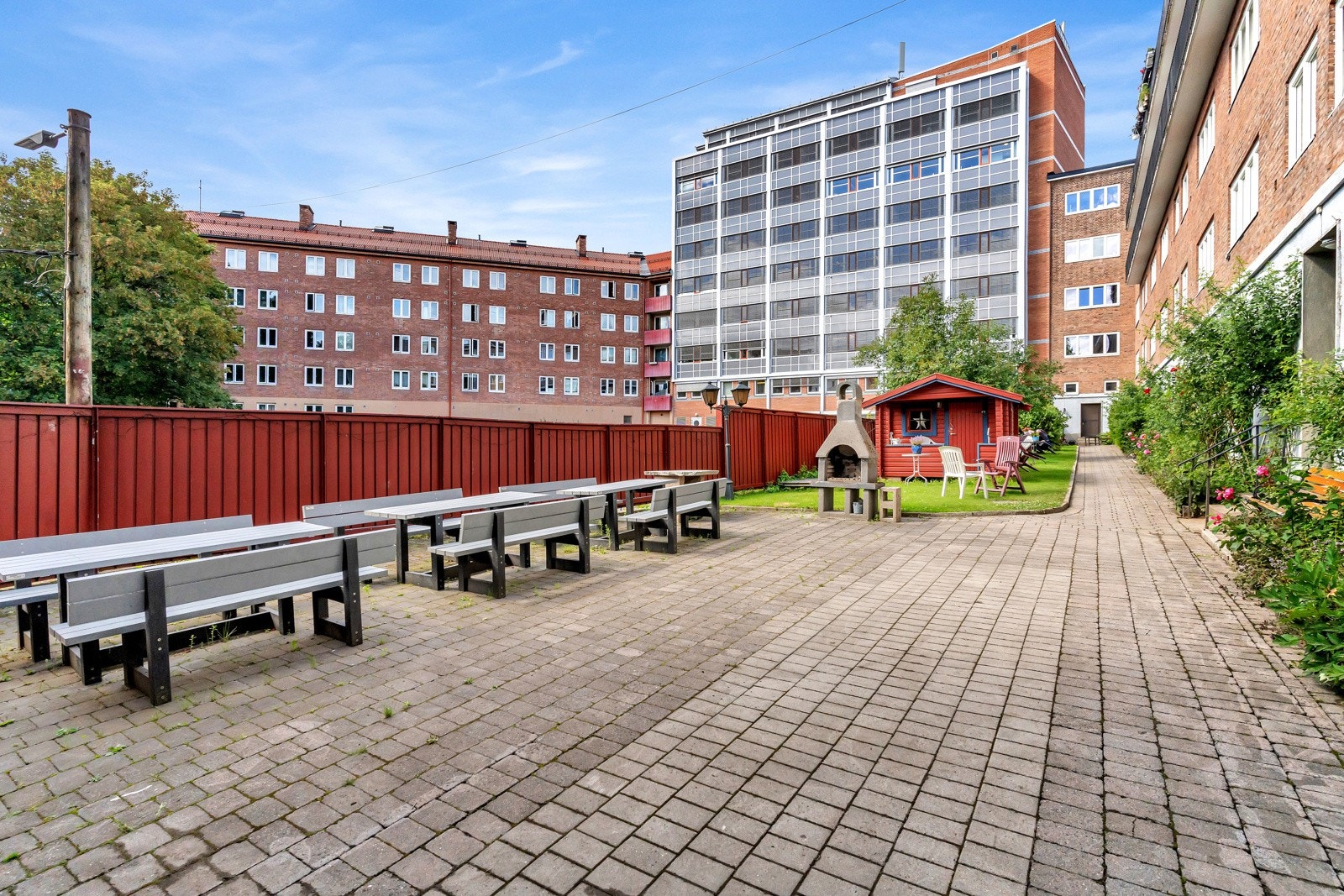 Bakgården består av belegningsstein, gressplen, sittegrupper og utegrill. Galleribilde