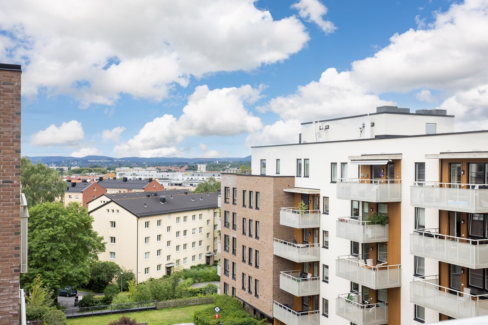 Utsikt fra balkongen mot grøntområde og nabolag. Galleribilde