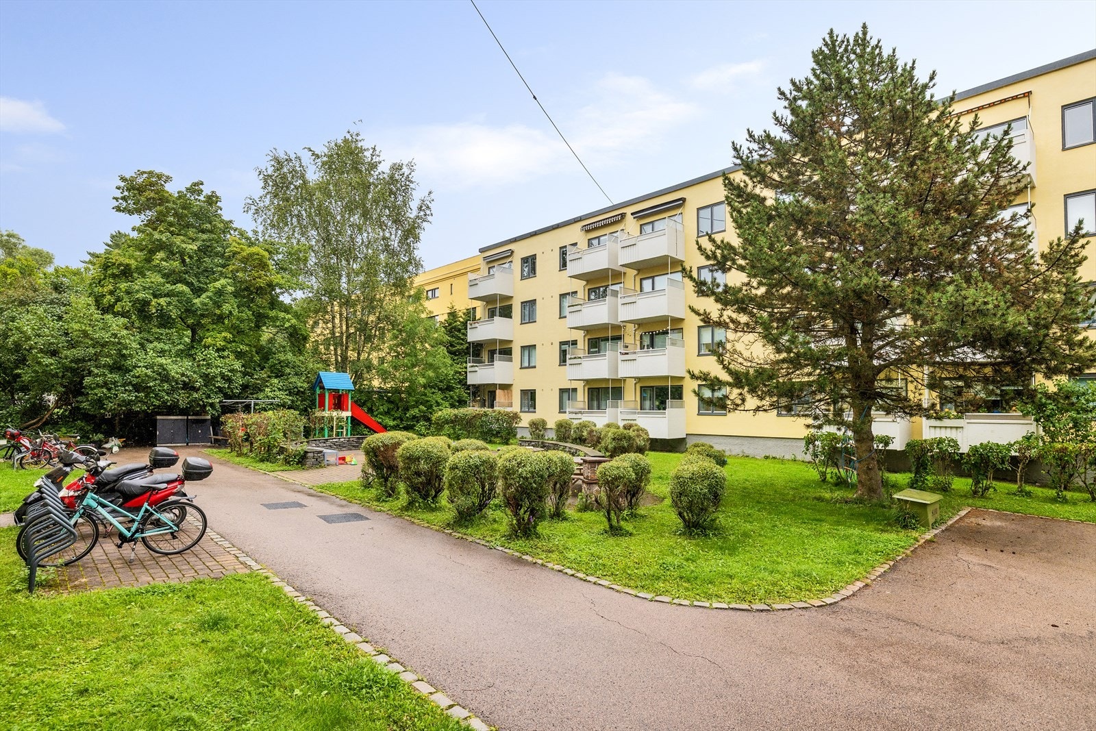 Borettslaget har en idyllisk og pent opparbeidet uteplass med internveier, plen og beplantning Galleribilde
