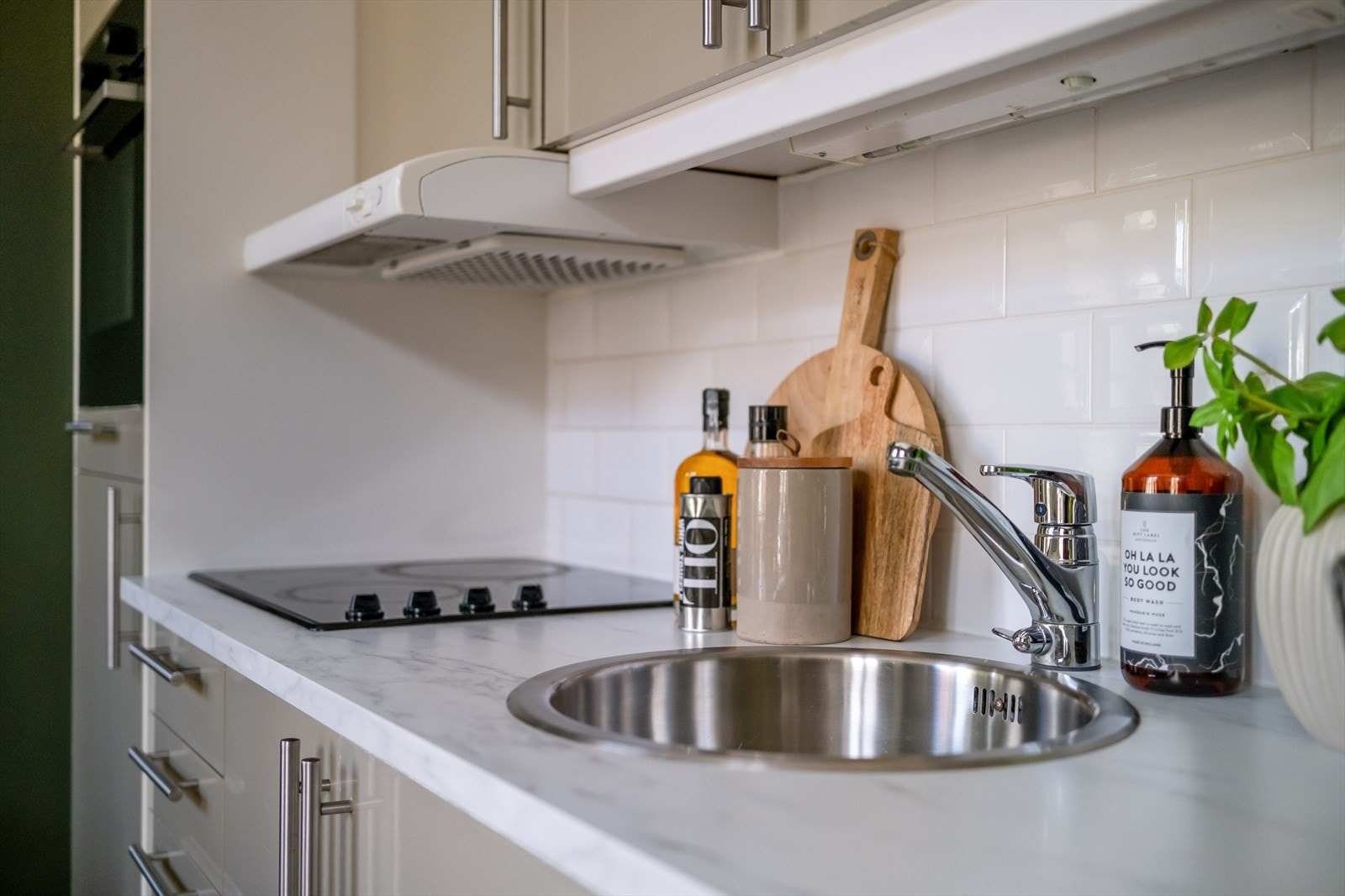 Innredning med mekanisk avtrekksvifte over stekesonen. Integrerte hvitevarer består av kjøleskap, stekeovn og platetopp. Frittstående oppvaskmaskin. Galleribilde