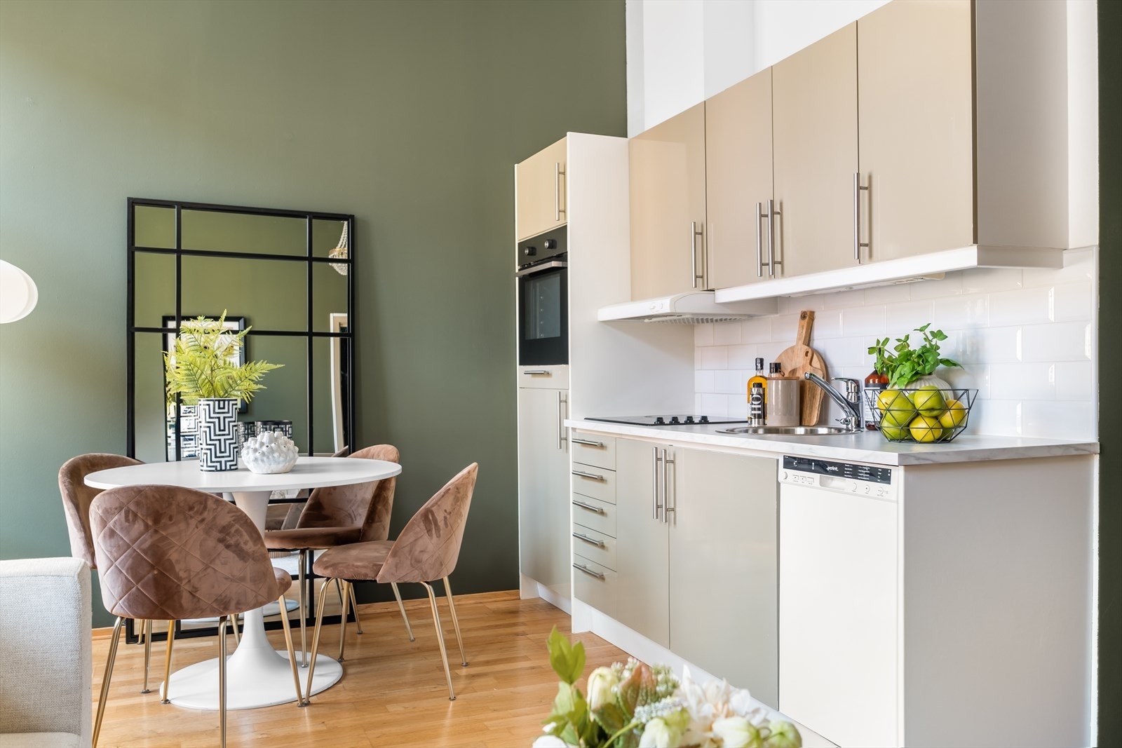 Tidløs innredning med beige, glatte fronter og benkeplate i laminat med nedfelt oppvaskkum og oppvaskmaskin. Galleribilde