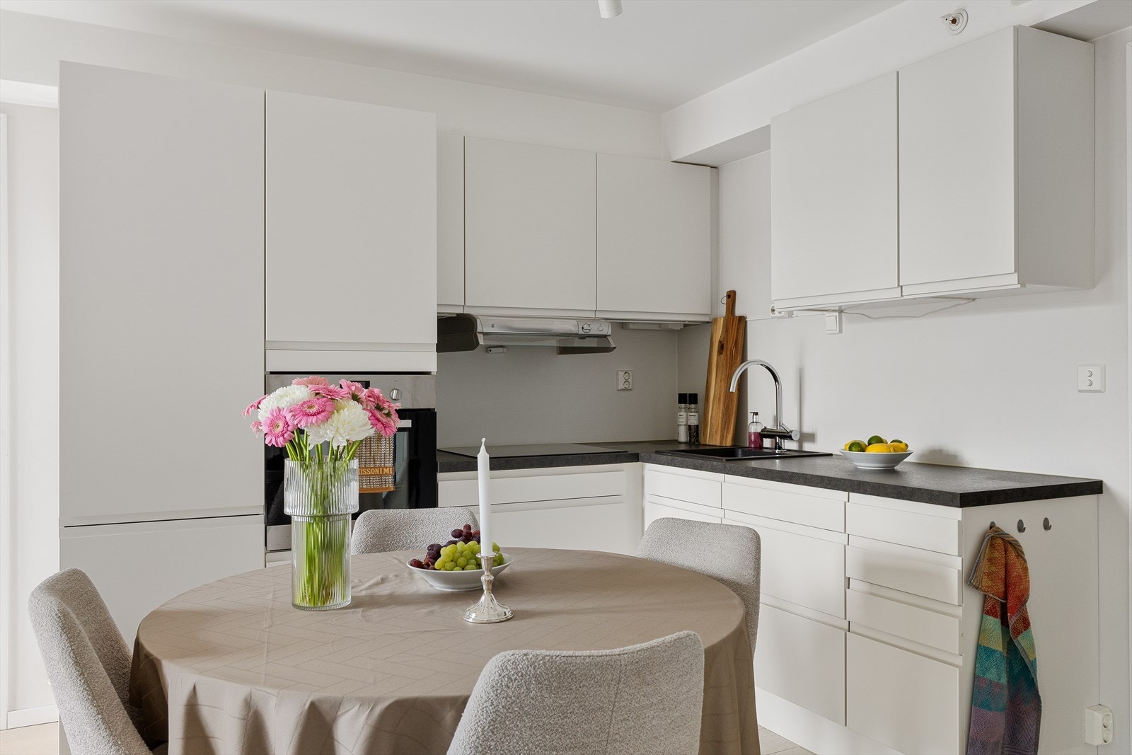 Lekkert kjøkken fra HTH med integrerte hvitevarer. Kjøkkeninnredningen har glatte fronter og laminat benkeplate med nedfelt kum i kompositt. Hvitevarer fra Whirlpool bestående av platetopp, stekeovn, oppvaskmaskin og kjøl-/fryseskap. Galleribilde