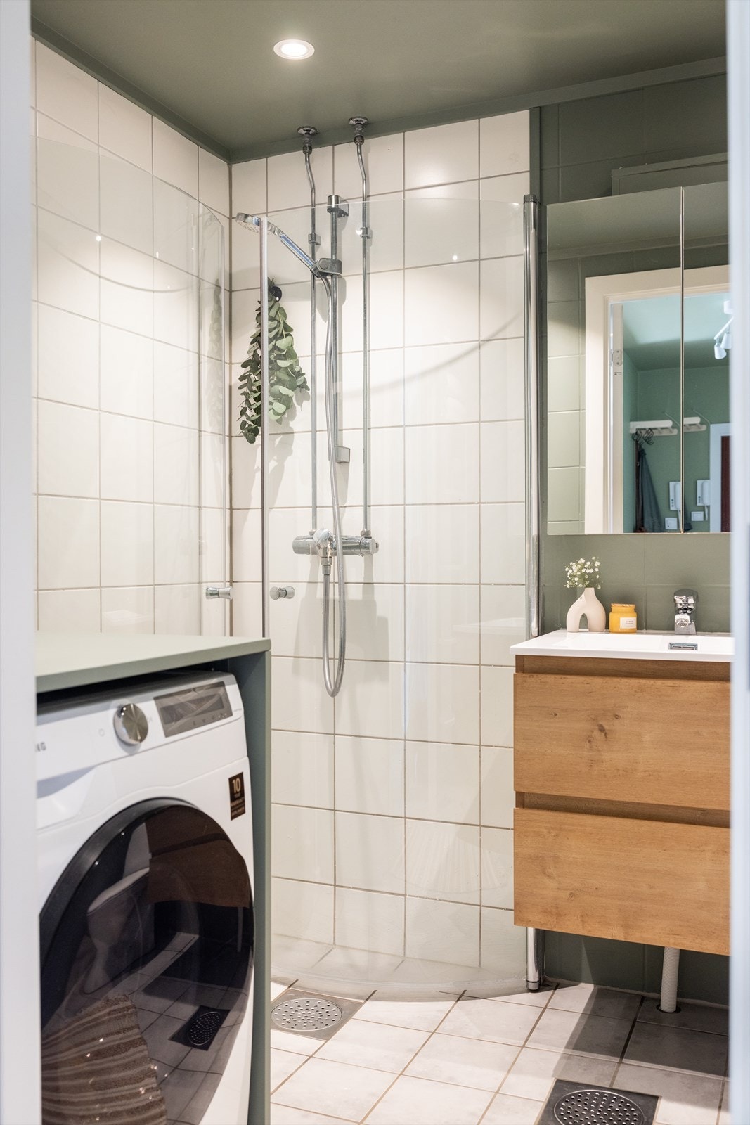 Badet er innredet med klosett, servant nedfelt i innredningen, speilskap og dusjhjørne med innfellbare glassdører. Galleribilde