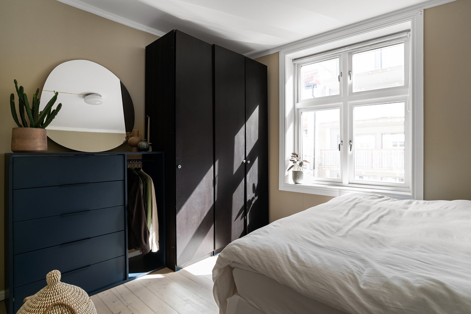 Den brunsorte garderobeløsningen er en elegant og stilsikker kombinasjon til den lekre veggfargen. Galleribilde