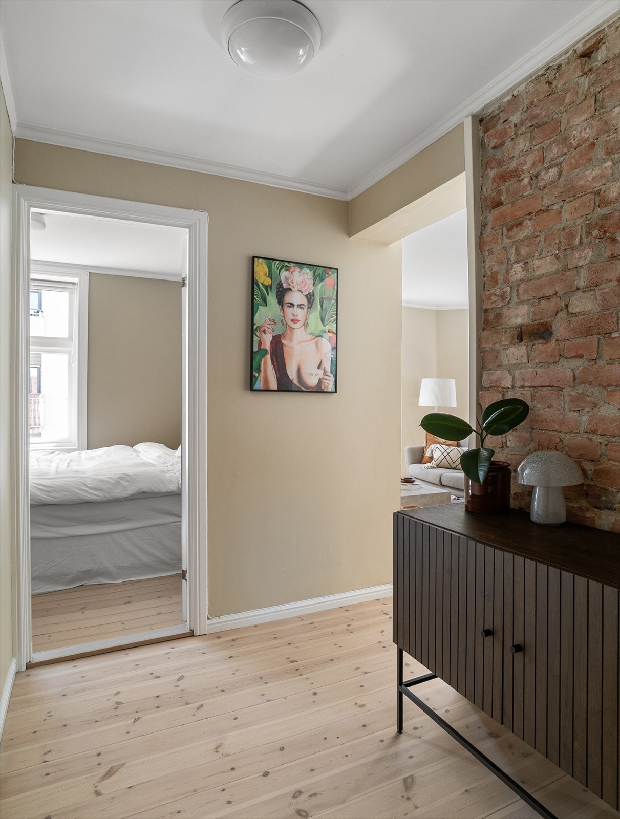 En kosellg mellomgang leder deg til soverom og bad. Den tøffe originale teglveggen hentet frem her og de slipte, originale tregulvene tilfører leiligheten en herlig dose sjarm og sjel. Galleribilde