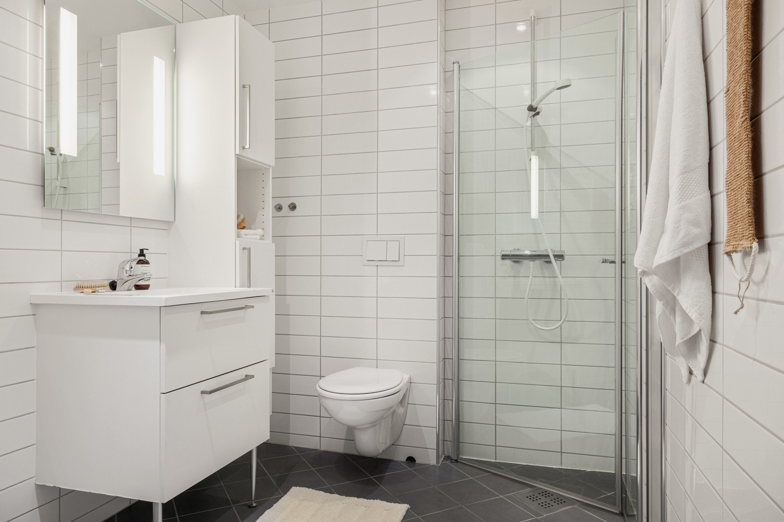 Badet på 4 kvm er helfliset med innfelte downlights i tak og vannbåren gulvvarme. Galleribilde